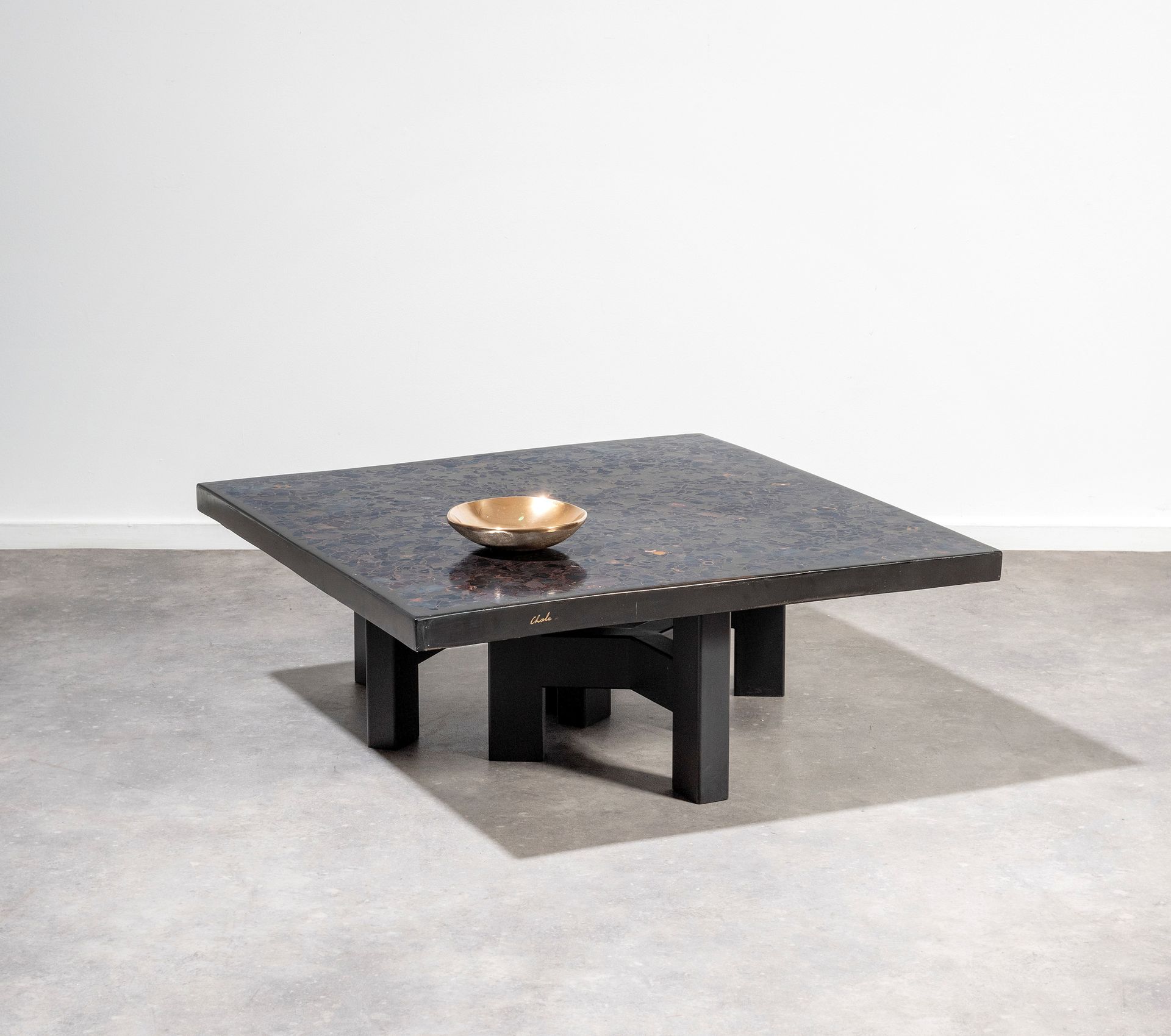 Ado CHALE (né en 1928) 咖啡桌
黑色树脂和赤铁矿马赛克的桌面，放在三个黑色漆面钢的三脚架腿上。
签名由一颗锡兰红宝石圈出的黄金加强。
将向&hellip;