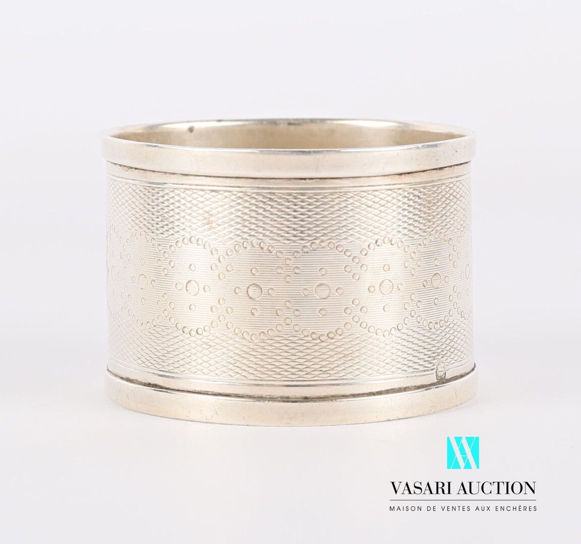 Null 银质餐巾环，装饰有一个雕刻的奖章，两侧是玑镂背景的叶子和交错的珍珠环。

重量：21.81克

高度：3.5厘米3,5 cm - 直径 : 5 cm