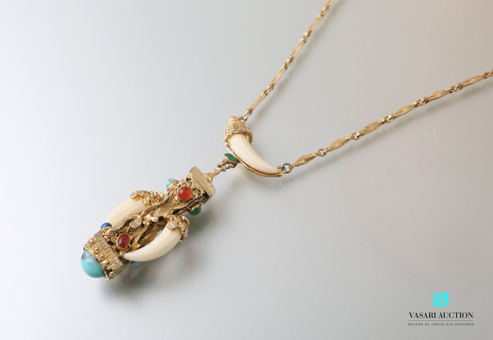 Null 镀金金属项链，链子上装饰有条状物，托着一个装饰有花朵、蛇的Diabolo形式的吊坠，装饰有凸圆形和仿制牙，扣环。

长度：39厘米