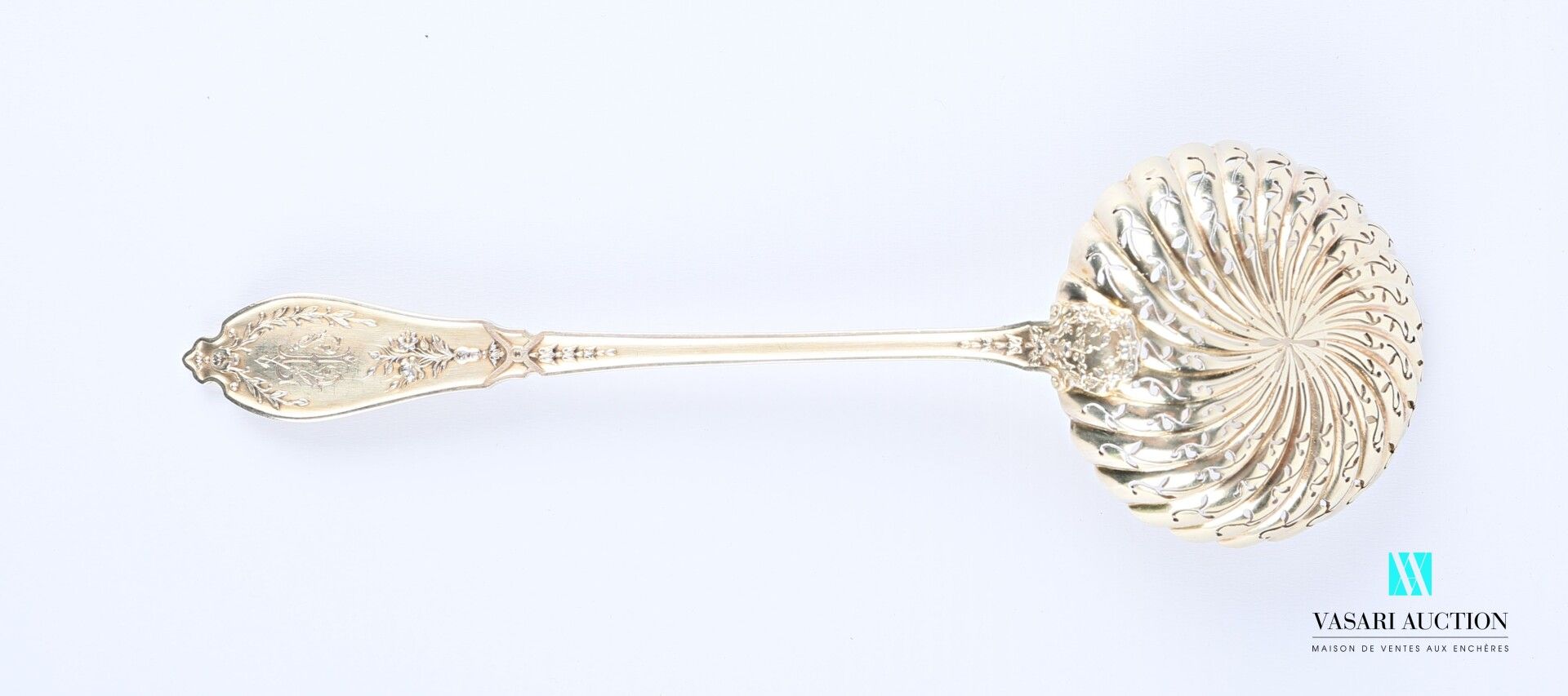 Null 银质洒水勺，柄部装饰有鱼片、花枝、月桂树枝和蝴蝶结，穿孔的勺子上装饰有风格化的叶子。

重量 : 65,09 g