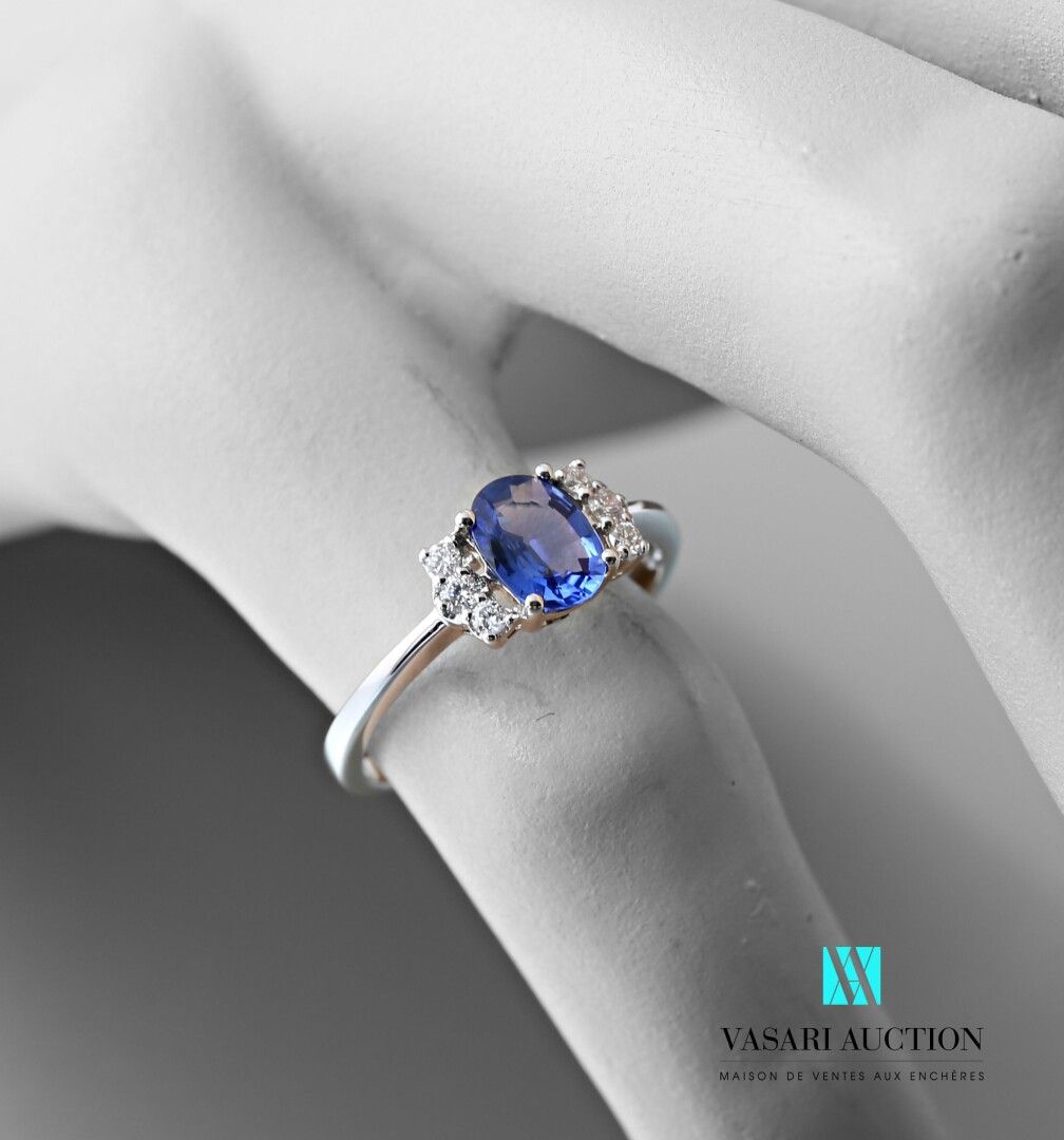 Null 750千分之一的白金戒指，中央装饰有一颗约0.85克拉的椭圆形蓝宝石，并由六颗现代大小的钻石支撑。

毛重：2.53克 - 手指尺寸：54