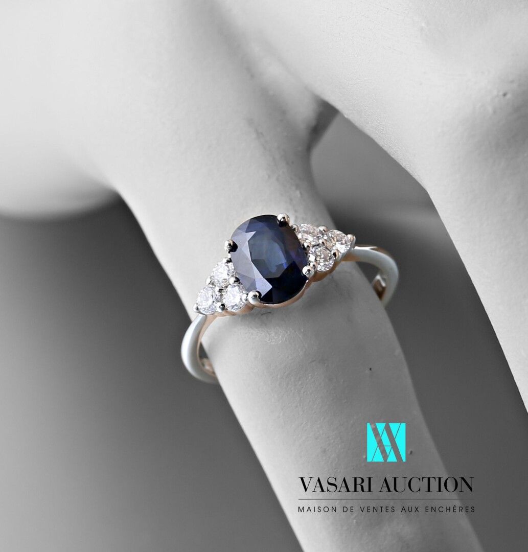 Null 750千分之一白金戒指，中央镶嵌一颗重达1.45克拉的椭圆形蓝宝石，并由六颗现代大小的钻石支撑。

毛重：2.69克 - 手指尺寸：54