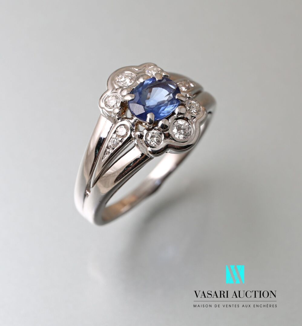 Null 750千分之一的白金戒指，中央镶嵌着一颗约1克拉的椭圆形蓝宝石，周围有三叶形的圆钻装饰。

毛重：6.79克 - 手指尺寸：55.5