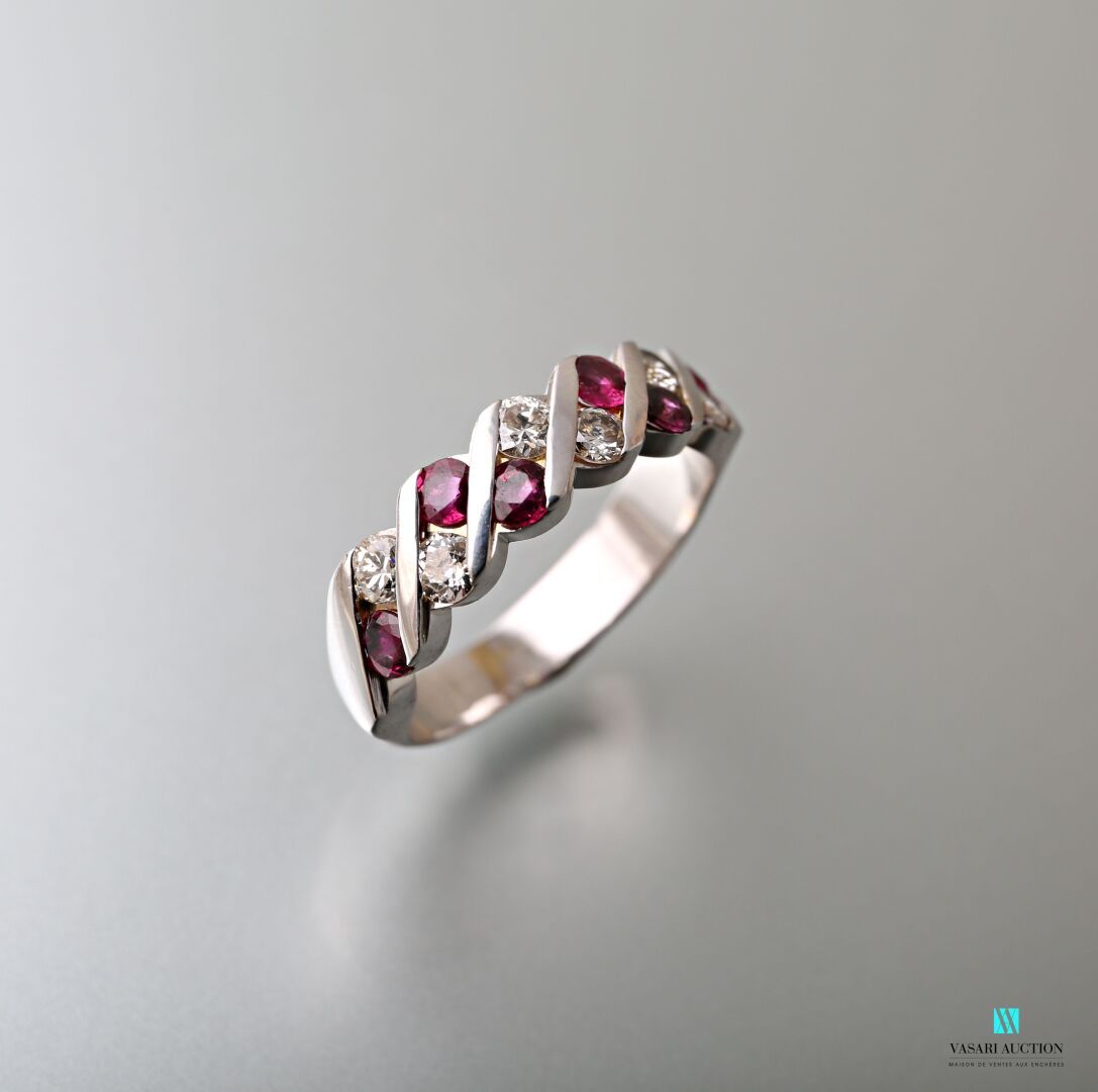 Null 750千分之一的白金半婚戒，装饰有六颗圆形红宝石的扭曲楣，总重0.60克拉，六颗圆形钻石，总重0.40克拉。

毛重 : 6,85 g