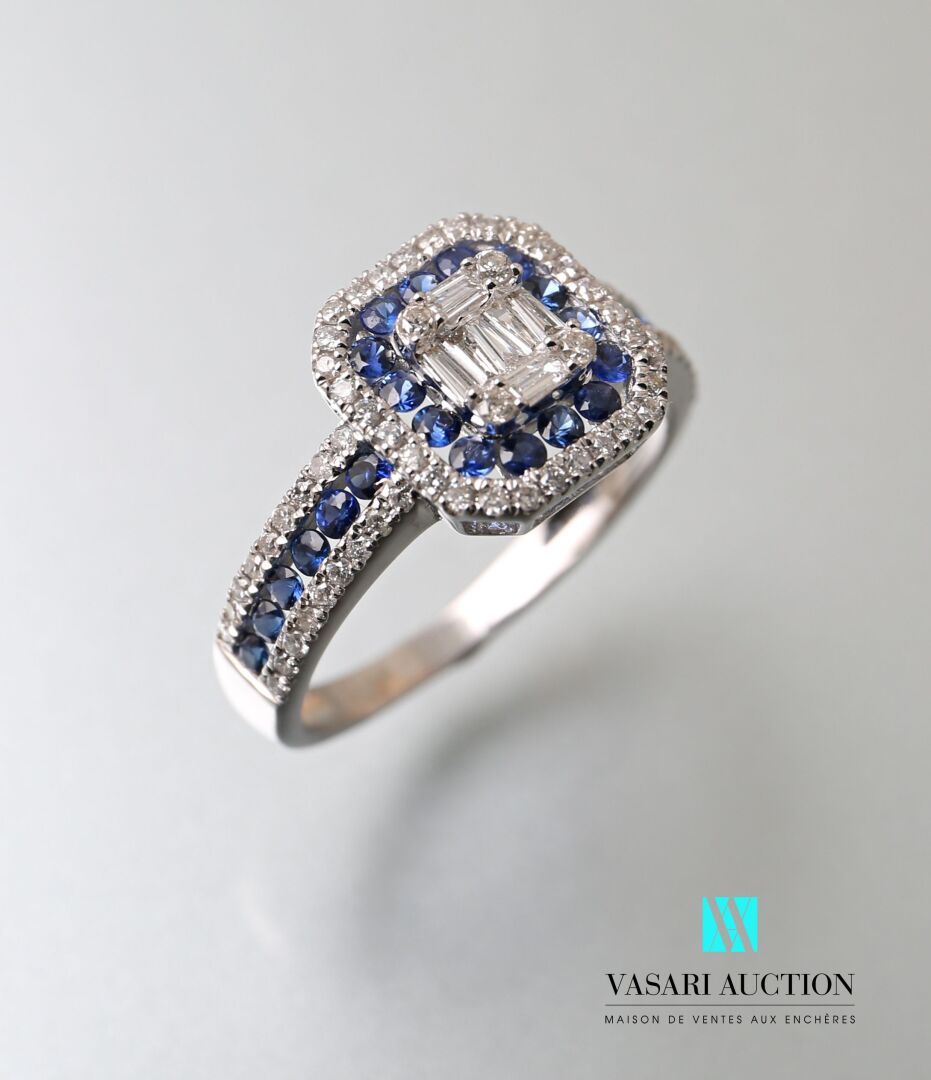 Null 白金75万分之一的艺术装饰风格的戒指，在其中心设置了七个长方形钻石，在肩上召回的钻石和圆形蓝宝石的双随从。

毛重：2.56克 - 手指尺寸：52
