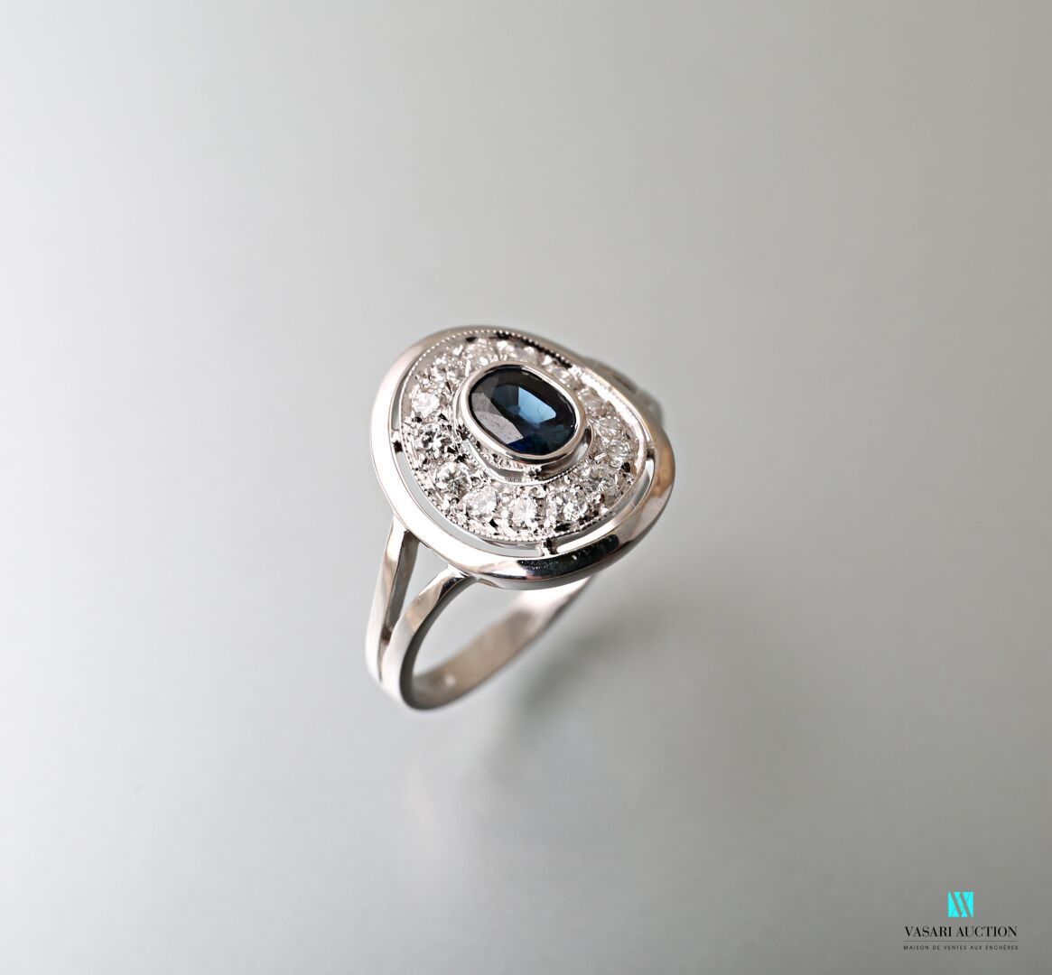 Null 750千分之一的白金椭圆形戒指，中央装饰有一颗约1.20克拉的椭圆形蓝宝石，采用封闭式镶嵌，边上有一排圆钻。

毛重：4.60克 - 手指尺寸：56