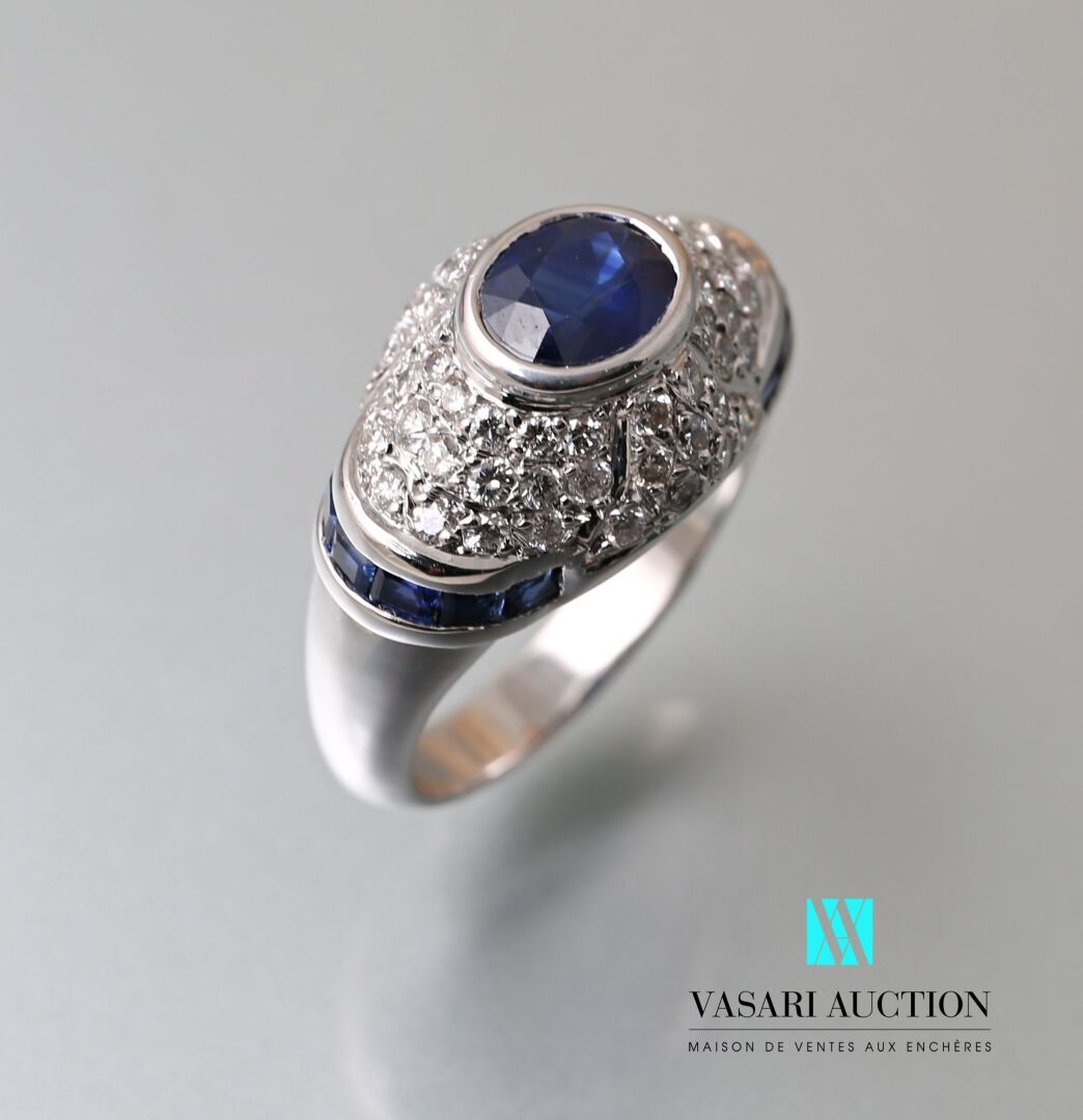 Null 白金圆顶戒指，中央镶嵌着一颗约1.10克拉的椭圆形蓝宝石，由圆钻密镶而成，肩部由一排校准的蓝宝石突出。

毛重：8.69克 - 手指尺寸：53