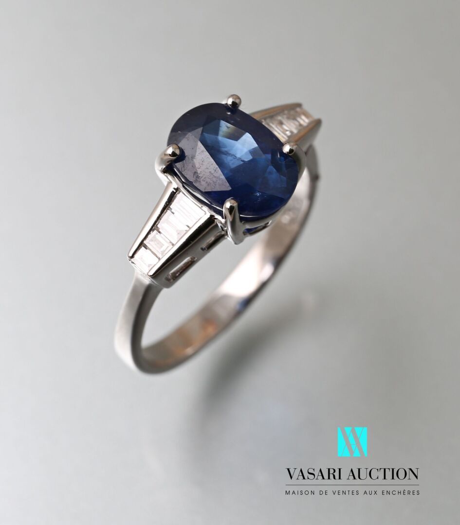 Null 750千分之一的白金戒指，中央有一颗2.60克拉的椭圆形蓝宝石，肩部有六颗大小不等的长方形钻石。

毛重：3.37克 - 手指尺寸：54