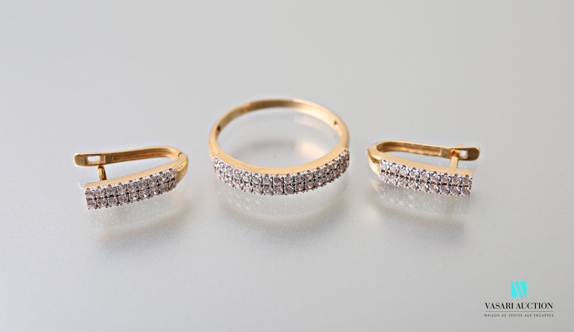 Null 半成品包括：一枚半成品结婚戒指和一对耳环，黄金75千分之一，镶有两行白色小仿石，重4.4克。

转指：55。耳环的长度为2厘米。