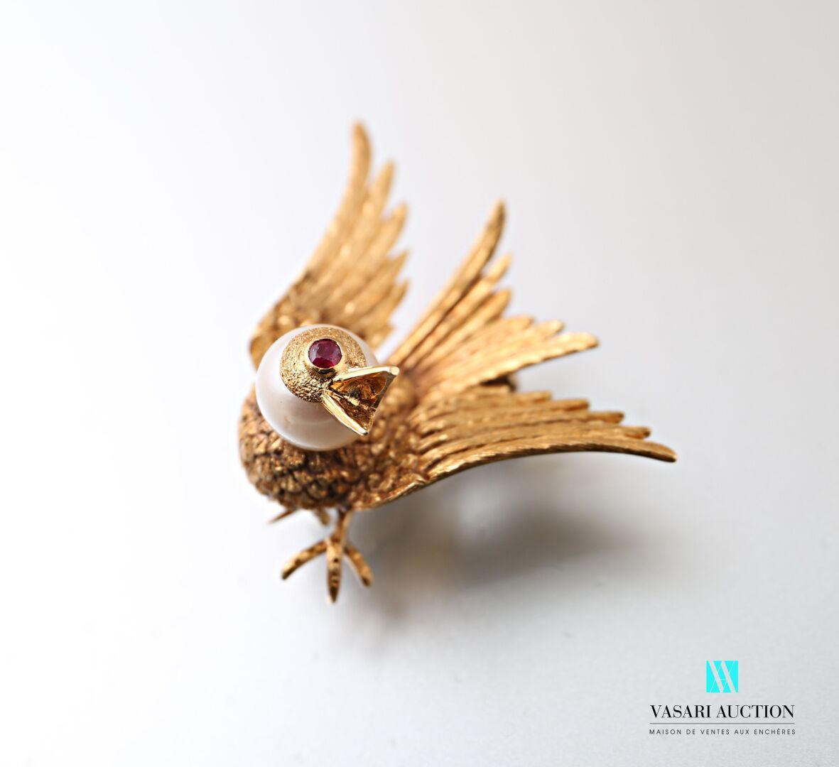 Null 黄金胸针，千分之七十五，鸟形，头部为文化珍珠，眼睛为红宝石，约1960年，10.9克。标有一个鹰头。

尺寸为3,5 x 3厘米。