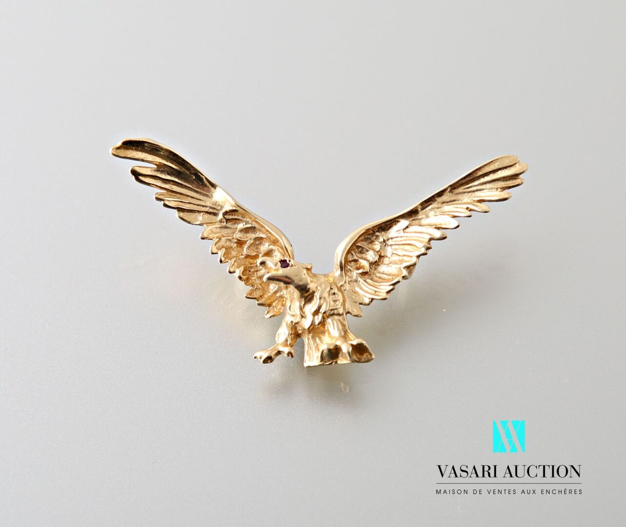 Null 鹰展翅的黄金吊坠，585千分之一熔化和追逐的形状

毛重：6.6克 - 尺寸：5.2×3厘米。

标志性的扇贝壳
