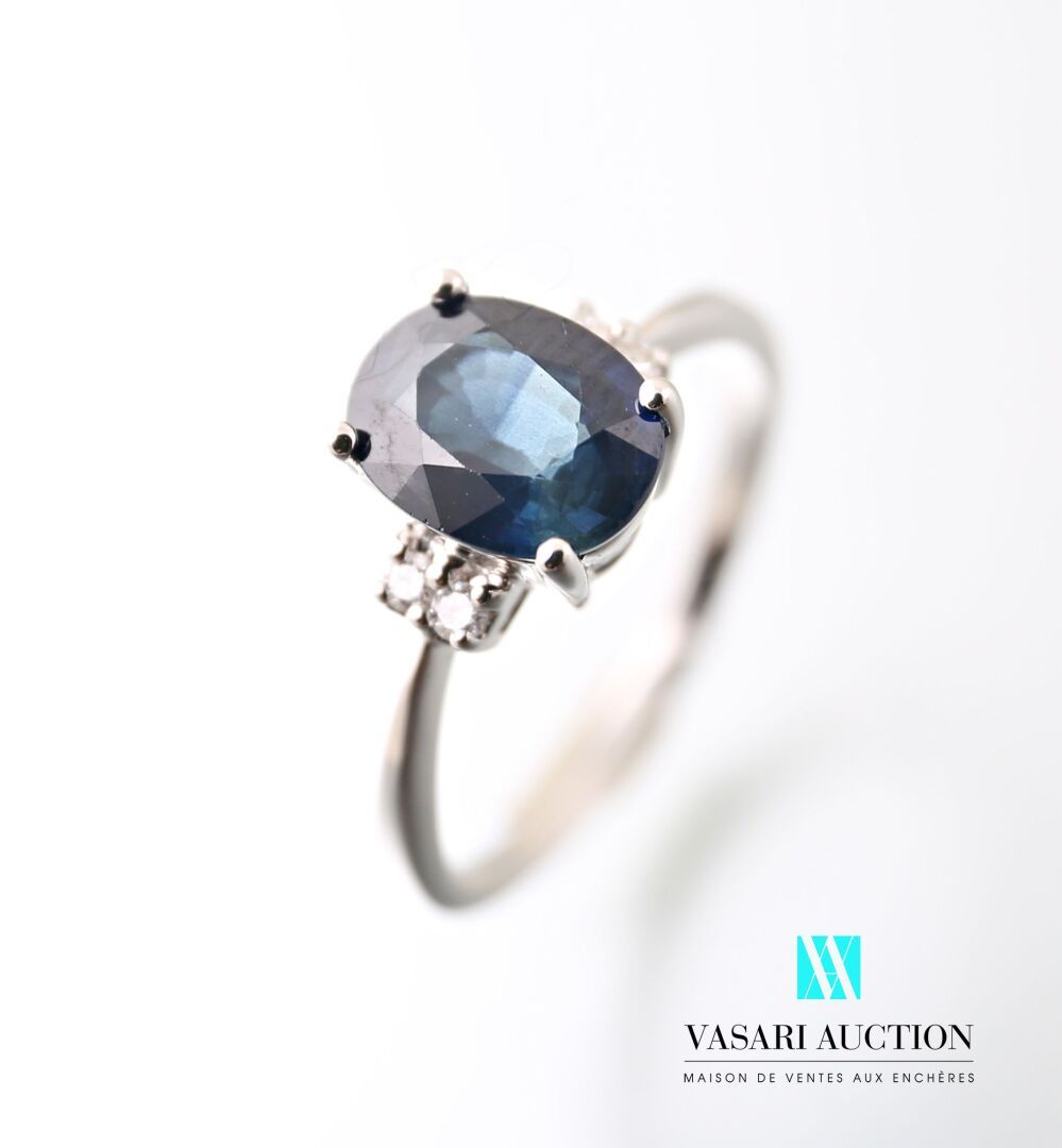 Null 750千分之一的白金戒指，镶有一颗约1.8克拉的椭圆形蓝宝石，由四颗现代大小的圆钻支撑。

毛重：2.92克 - 手指尺寸：53