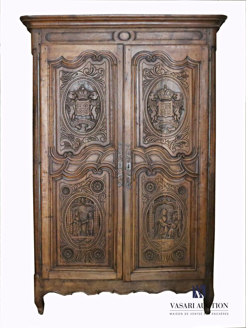 Null 一个模制和雕刻的天然木制橱柜，两扇门上装饰着皇冠状的纹章，上面有两只狮子，下面有历史性的场景，周围有刺桐叶卷轴和玫瑰花。它用四条腿站立，前面的腿呈拱形&hellip;