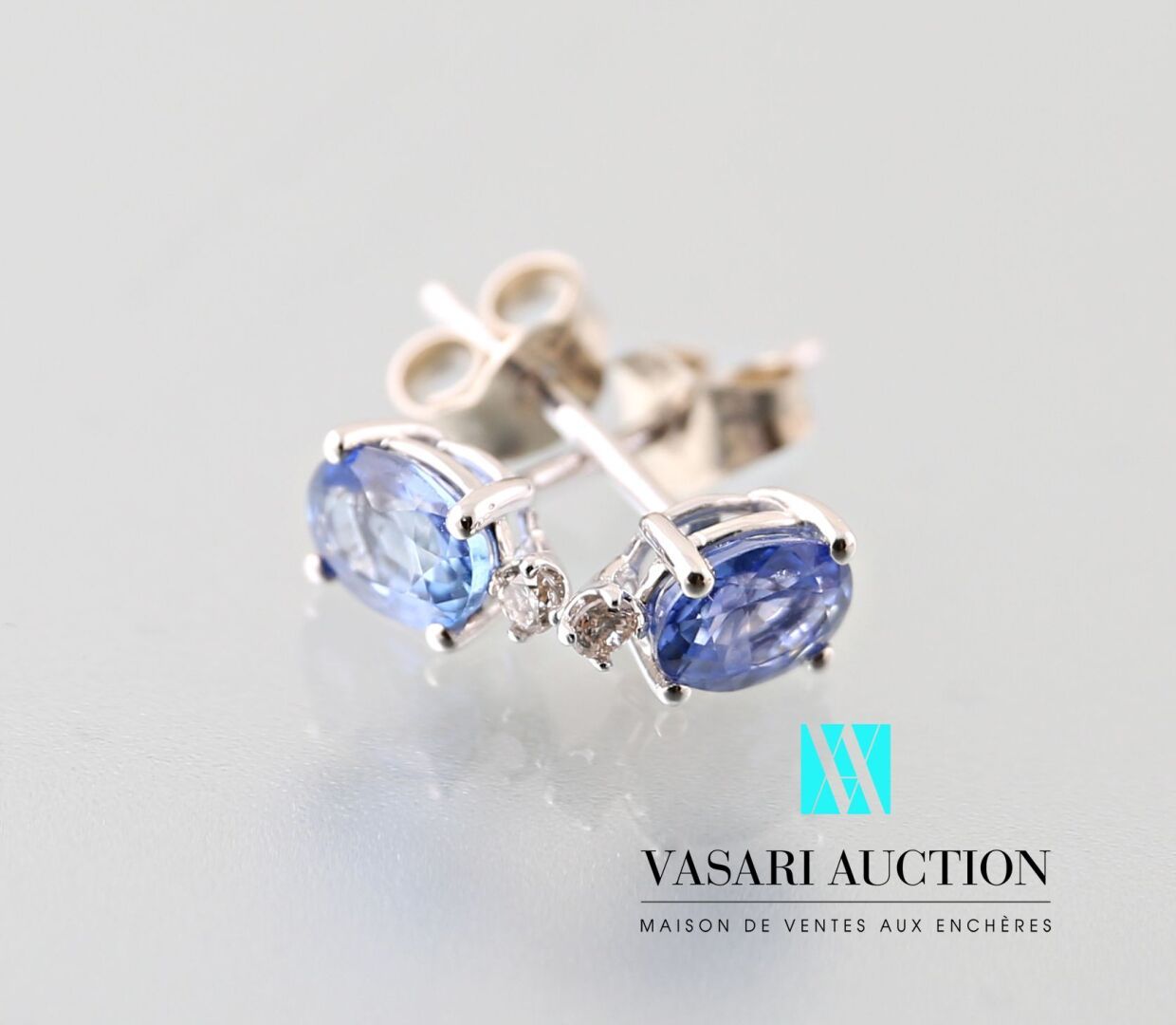 Null 750千分之一白金耳环一对，装饰有两颗椭圆形蓝宝石，上面有一颗现代钻石，比利时扣子。
毛重 : 0,84 g