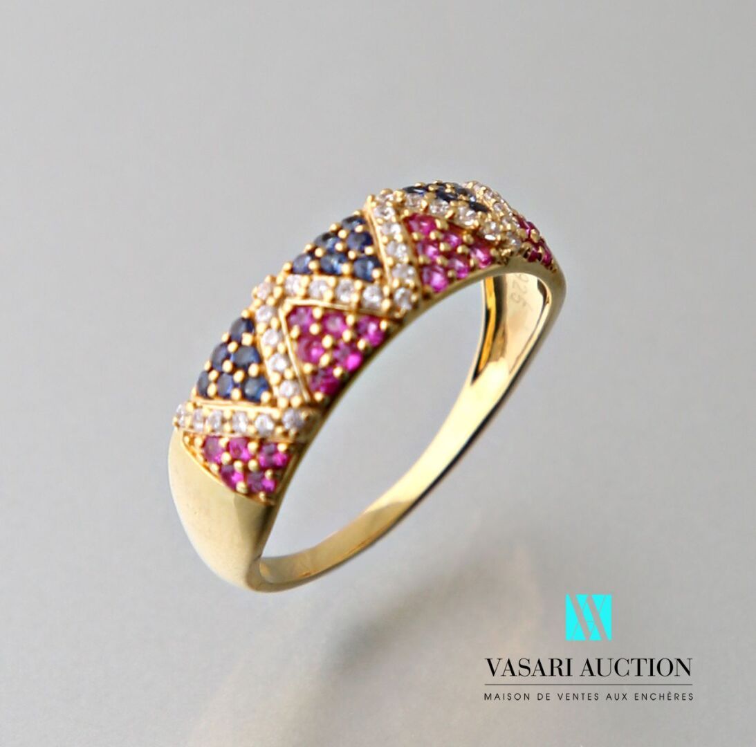 Null 一枚镶有三角图案的青铜戒指，上面铺满了红宝石和处理过的蓝宝石。
毛重：2.04克 - 手指尺寸：56.5毫米