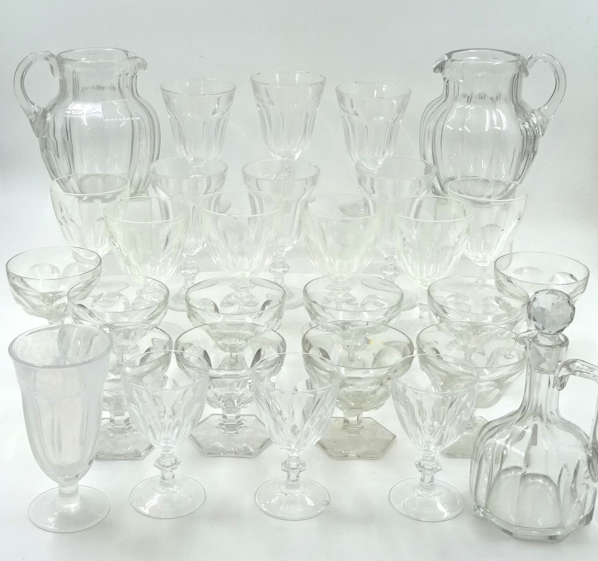 Null 一套不同尺寸的玻璃杯，采用巴卡拉 Harcourt 玻璃杯的风格。两个水壶（高 18 厘米）和一个玻璃瓶（高 18 厘米）。有些缺口和磨损。