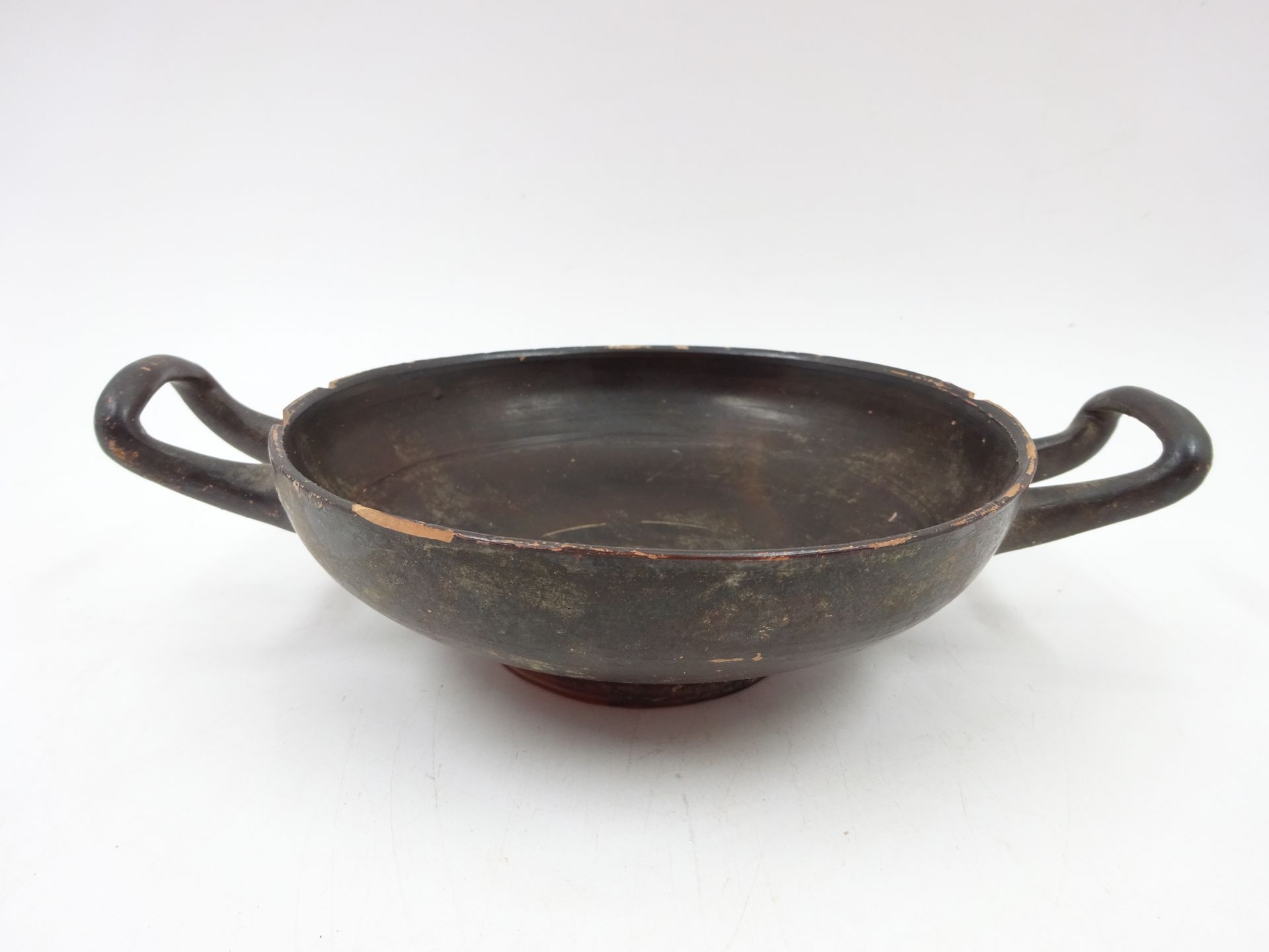 Null 黑釉杯，赤陶。坎帕尼亚式。直径（不含把手）：14.5 厘米。高：5 厘米（有缺口和缺损）。
专家：丹尼尔-勒伯里埃尔先生