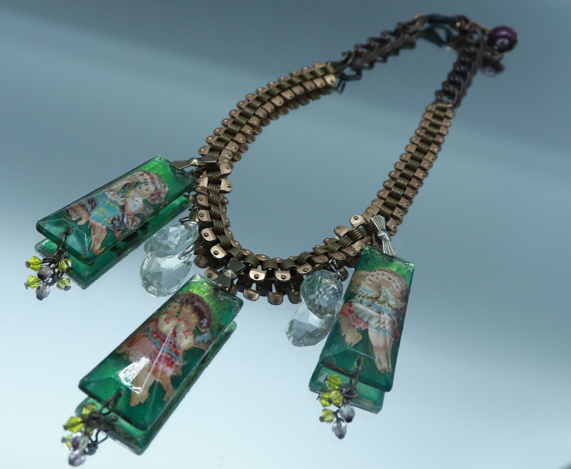 Null Halskette aus Metall, die mit drei Glasanhängern endet, die geflügelte Enge&hellip;