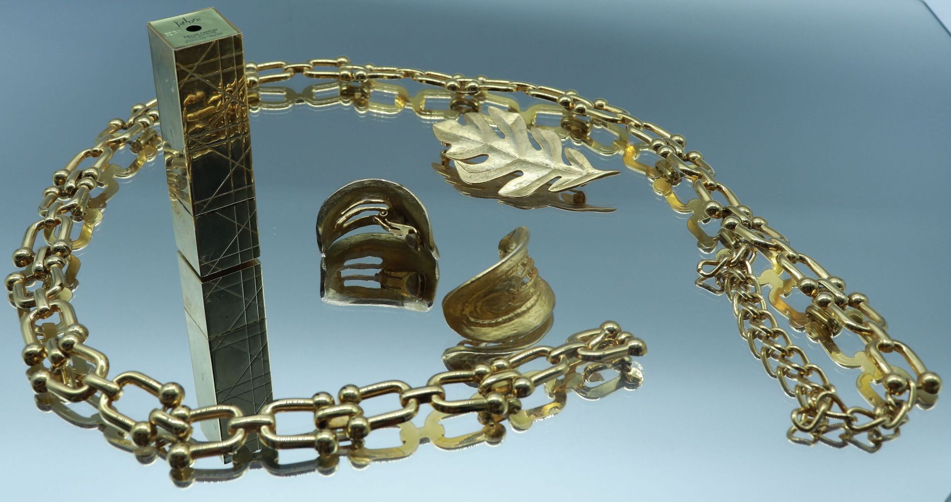 Null 一批镀金的金属首饰，包括:

- 一对花瓣形状的镀金金属耳夹。长度： 4.5 cm

- 一枚橡树叶形状的胸针。长度： 8,5 cm

- 一条带有马&hellip;