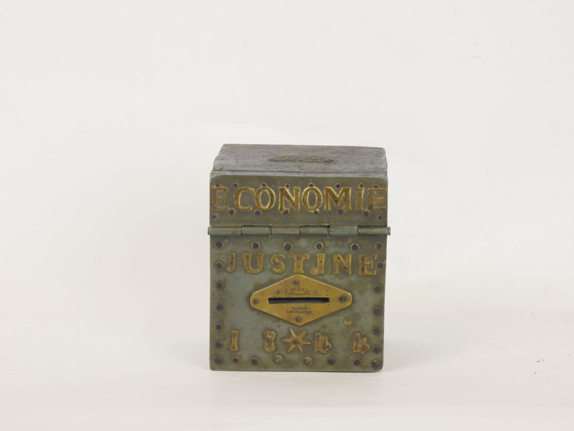 Null 木制钱箱，金属板上刻有 "Économie Justine 1844 "字样。它里面有一个牌子："致1840年6月27日出生在内韦尔的贾丝廷-勒尚特。&hellip;