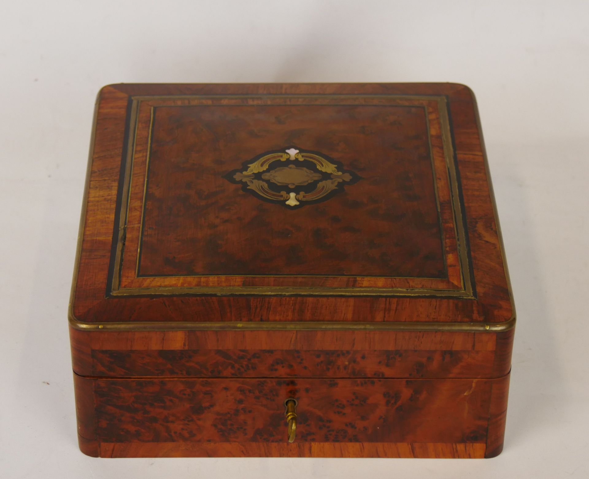 Null 一个正方形的癭木和鎏金黄铜贴面的箱子，中心有一个黄铜、珍珠母和发黑的木头组成的饰有树叶的方框。内部是有填充物的。有了它的钥匙。拿破仑三世时期

尺寸：&hellip;