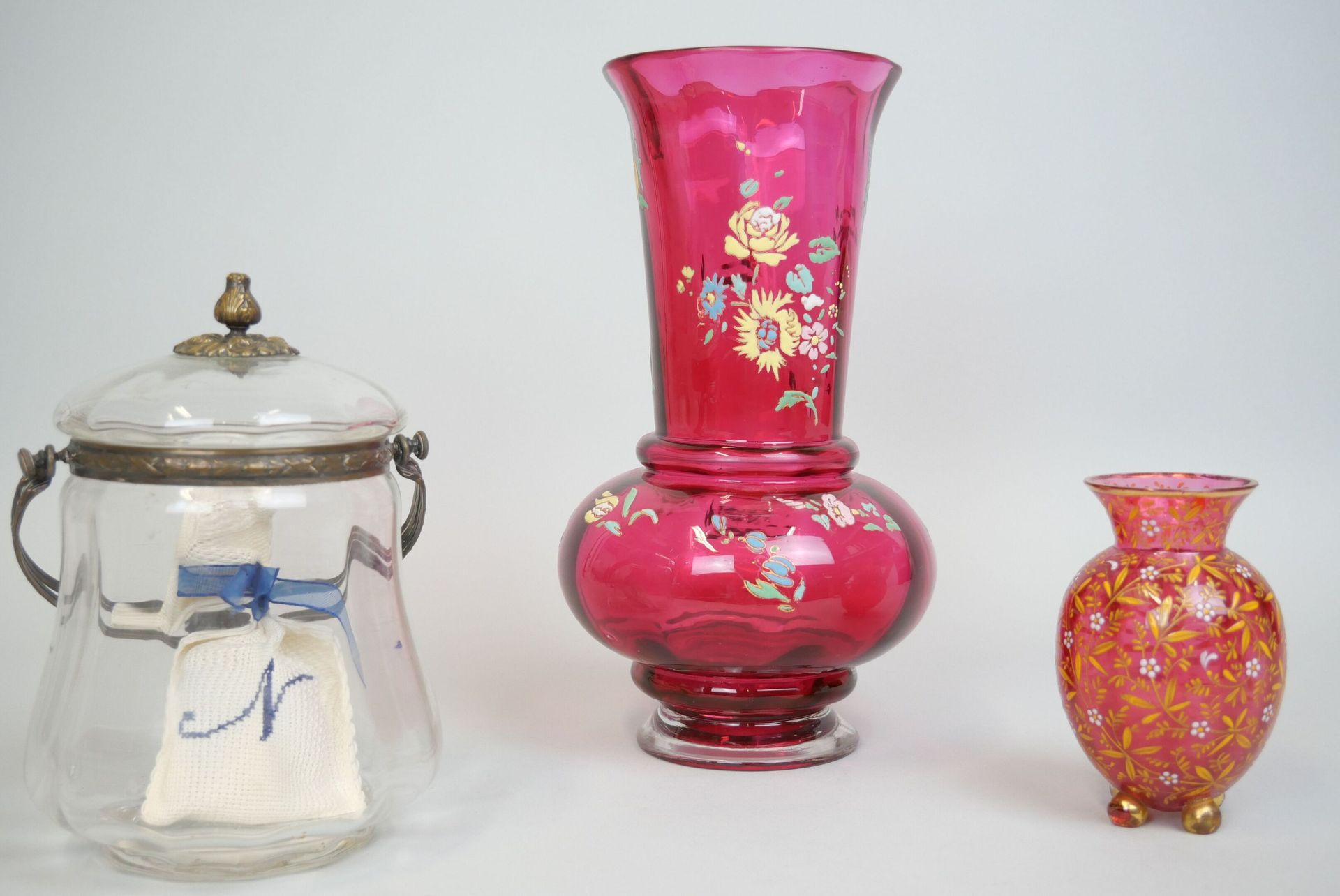 Null 一批玻璃器皿包括:

- 一个红色的有色玻璃小花瓶，上面有珐琅彩的花纹，放在一个四角形的底座上。高度：12厘米

- 一个大的红色着色玻璃花瓶，圆形底&hellip;