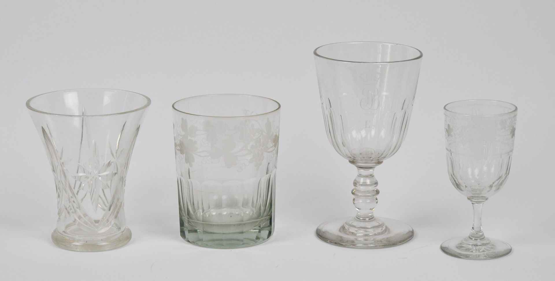 Null 一批玻璃器皿包括:

一个有刻面装饰和刻有葡萄和葡萄叶图案的玻璃杯。带有贝尔特-埃弗拉德1883年的题词。高度：15厘米

一个大的圆形玻璃，装饰有切&hellip;
