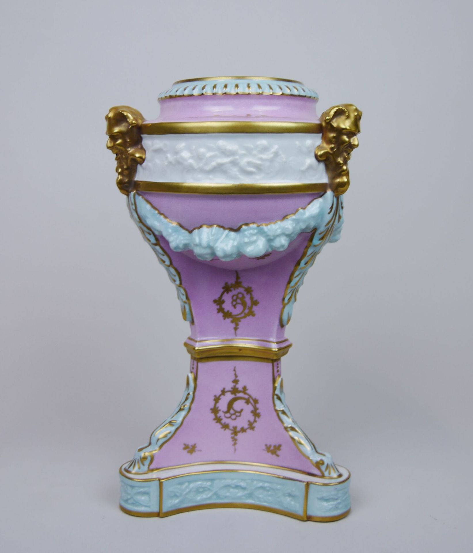 Null 瓷瓮花瓶在三脚架底座上，装饰有金色的萨提尔，花环和粉红色和绿松石的刺桐叶。19世纪末的作品

尺寸：34 x 20 cm (状况良好，缺少封面)


&hellip;