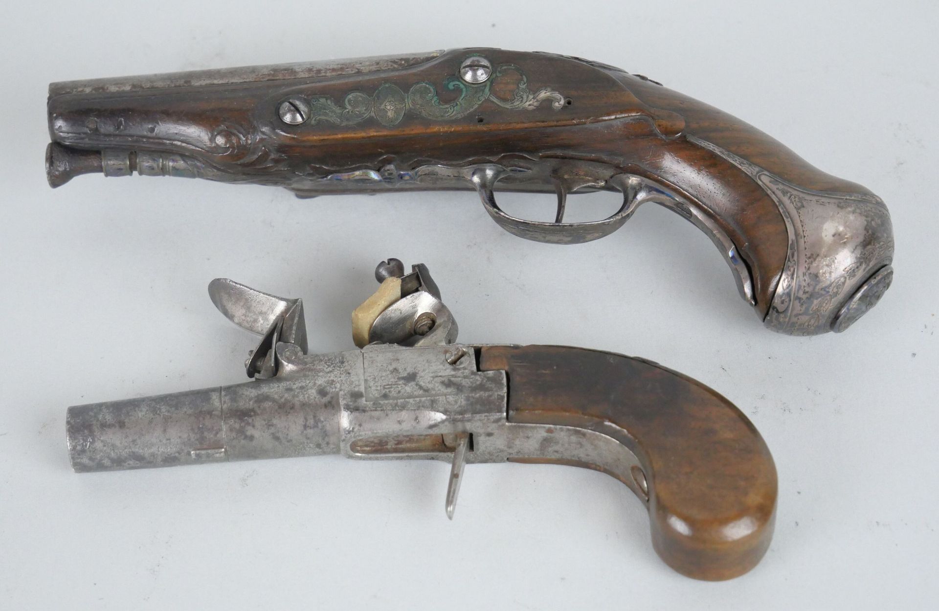Null 胡桃木，钢和银的燧发枪。

在昂热签署了MARTIN。

长：19厘米。

附有一把19世纪的小手枪。长：14.5厘米。



专家：MB艺术专家--&hellip;
