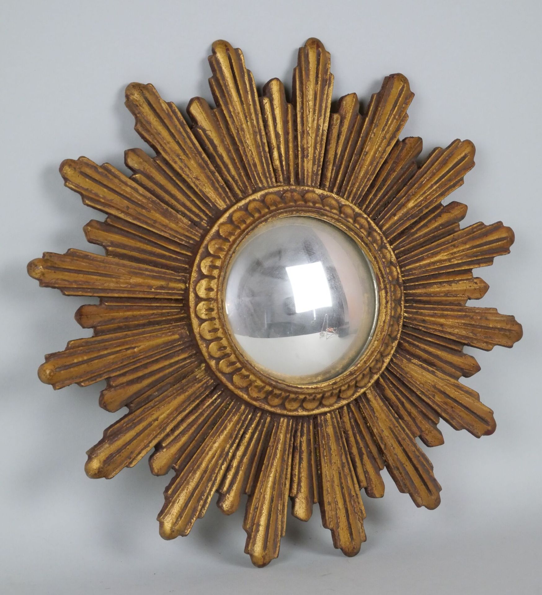 Petit miroir de sorcière en bois sculpté et doré à décor de rayons. 
Diamètre : &hellip;