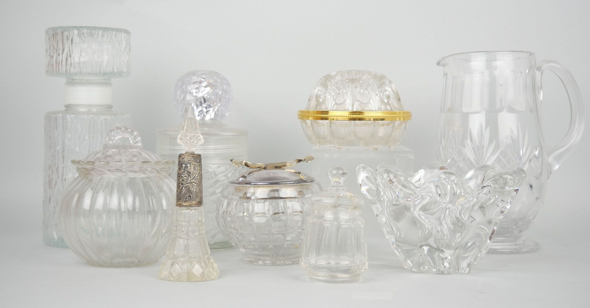 Null 一批玻璃器皿包括:

一个刻有菠萝装饰的水晶壶。尺寸：21 x 14 cm

一个小型模制玻璃瓶。尺寸：22 x 8 cm

一个有盖的ROCHAS风&hellip;