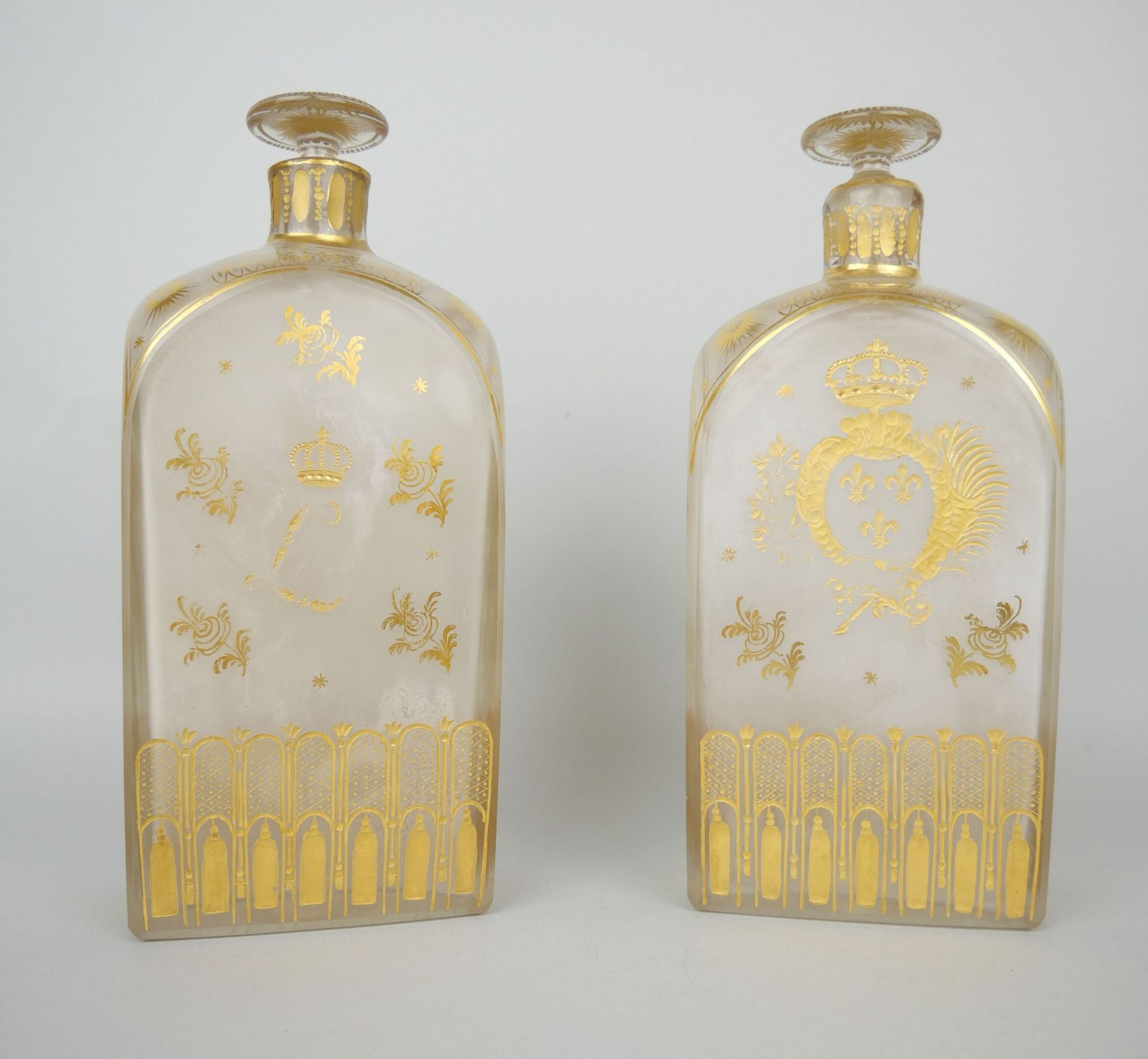 Deux bouteilles en verre de forme rectangulaire à décor doré représentant les at&hellip;