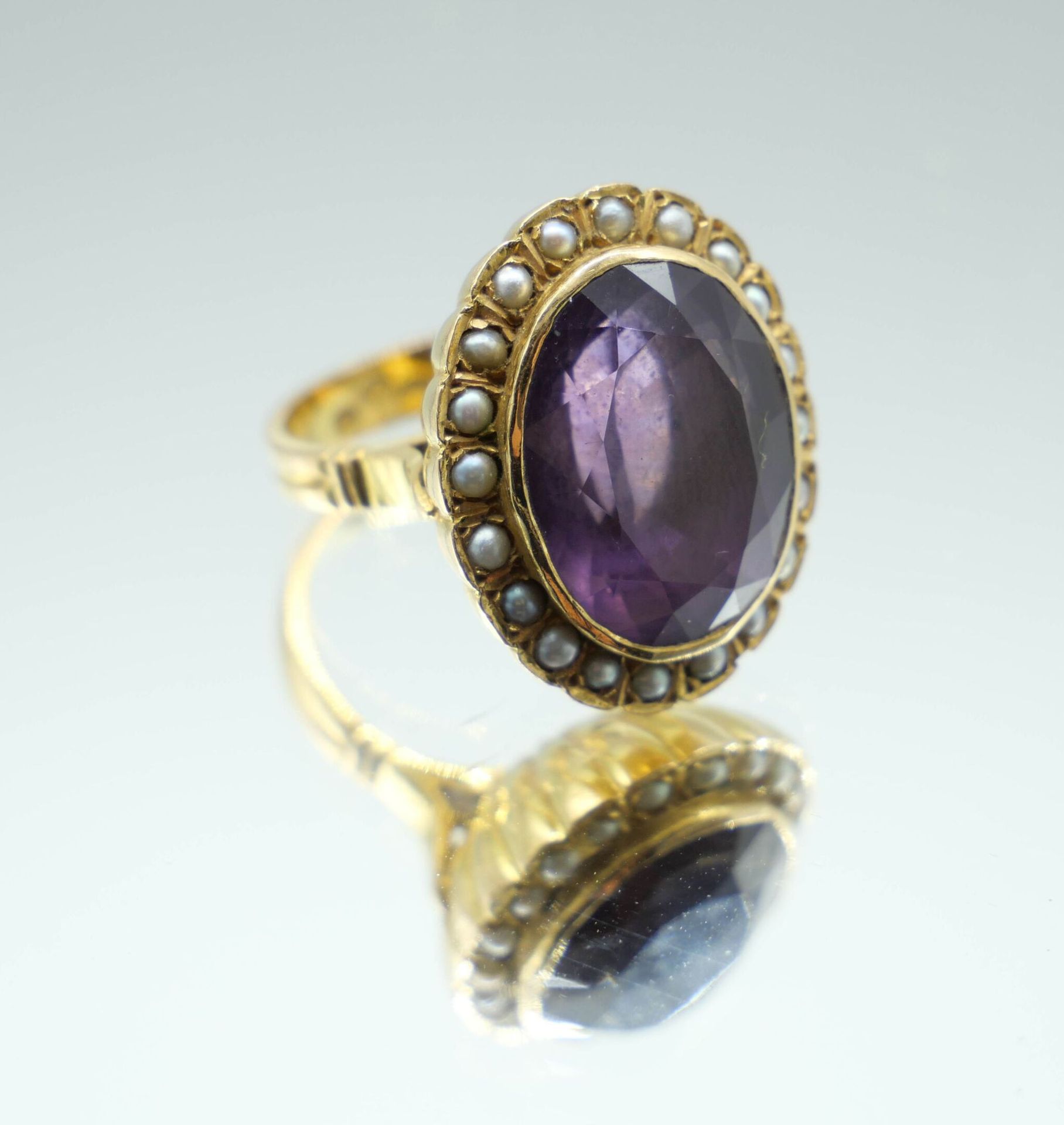 Null Ring aus 750er Gold, in dessen Mitte ein Amethyst in einer Umgebung aus kle&hellip;