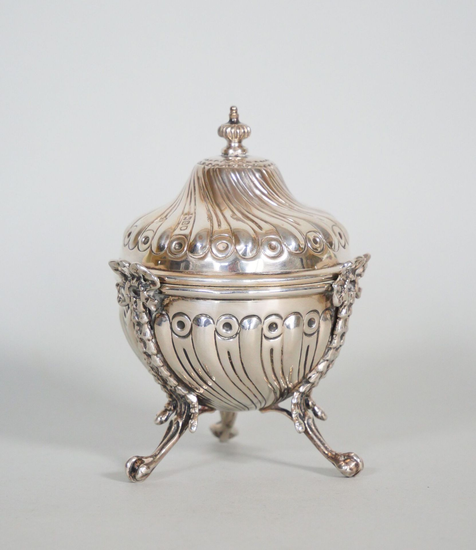 Null 银制小三角糖碗（925/1000），装饰有扭曲的笛子和丝带蝴蝶结。碗盖是一个旋转的陀螺形状。 
英国，伦敦，1901年。
重量 : 158克 (约)
&hellip;