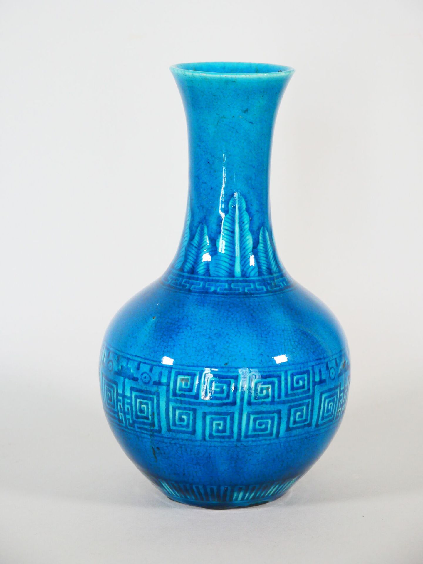 Null 中国：
绿松石蓝釉瓷瓶，颈部刻有雷文楣和香蕉叶的装饰。 
清朝末年。
(烧制缺陷)。 
高: 21.5厘米 

专家 : MB ART EXPERTI&hellip;