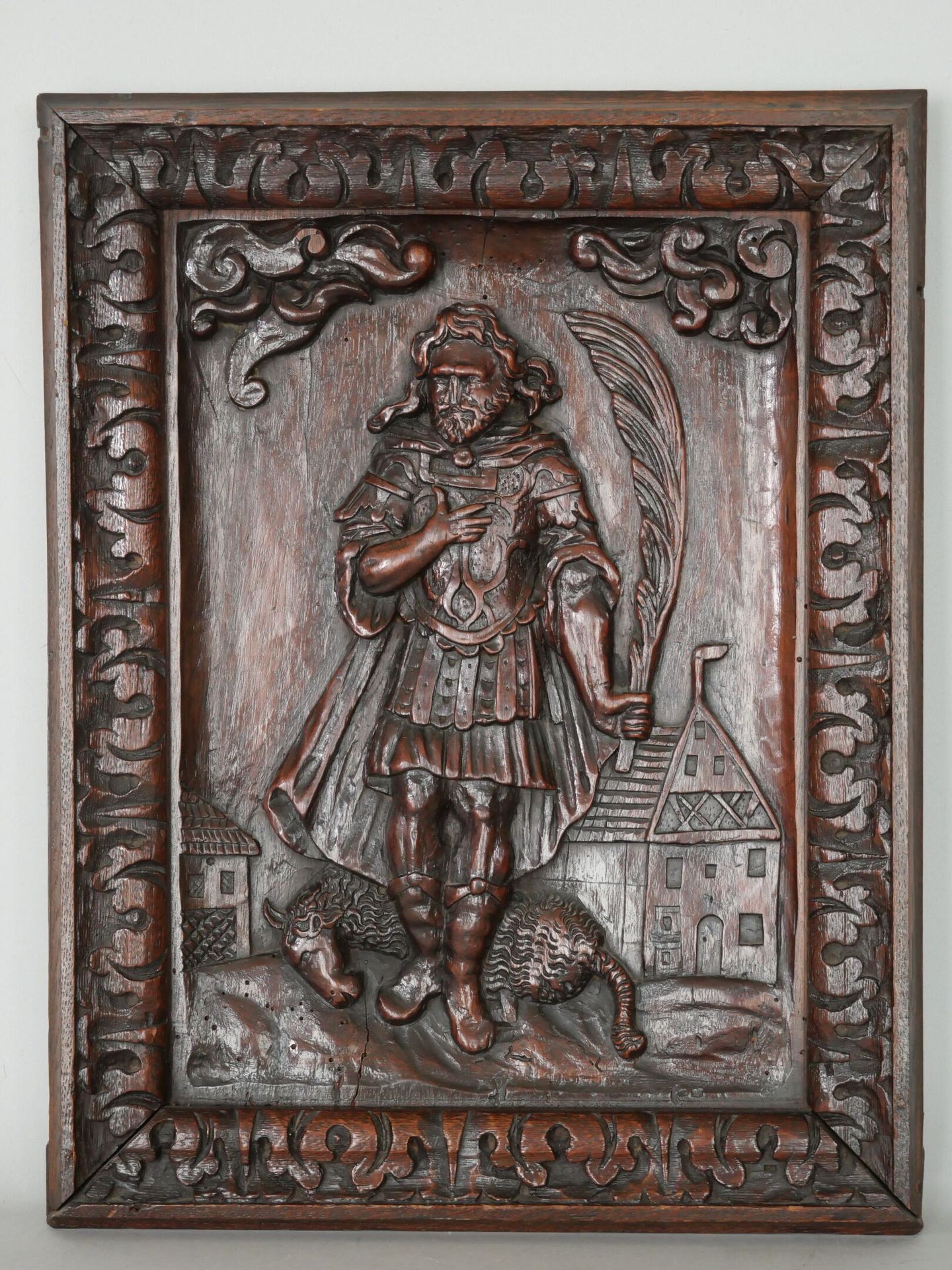 Null 着色的木质浮雕描绘了一位圣人，脚下是棕榈叶和一只小羊。由叶子的楣框框住。 
17世纪。 
可能是一件家具的装饰板。 
(裂缝和木虫的痕迹）。 
尺寸：&hellip;