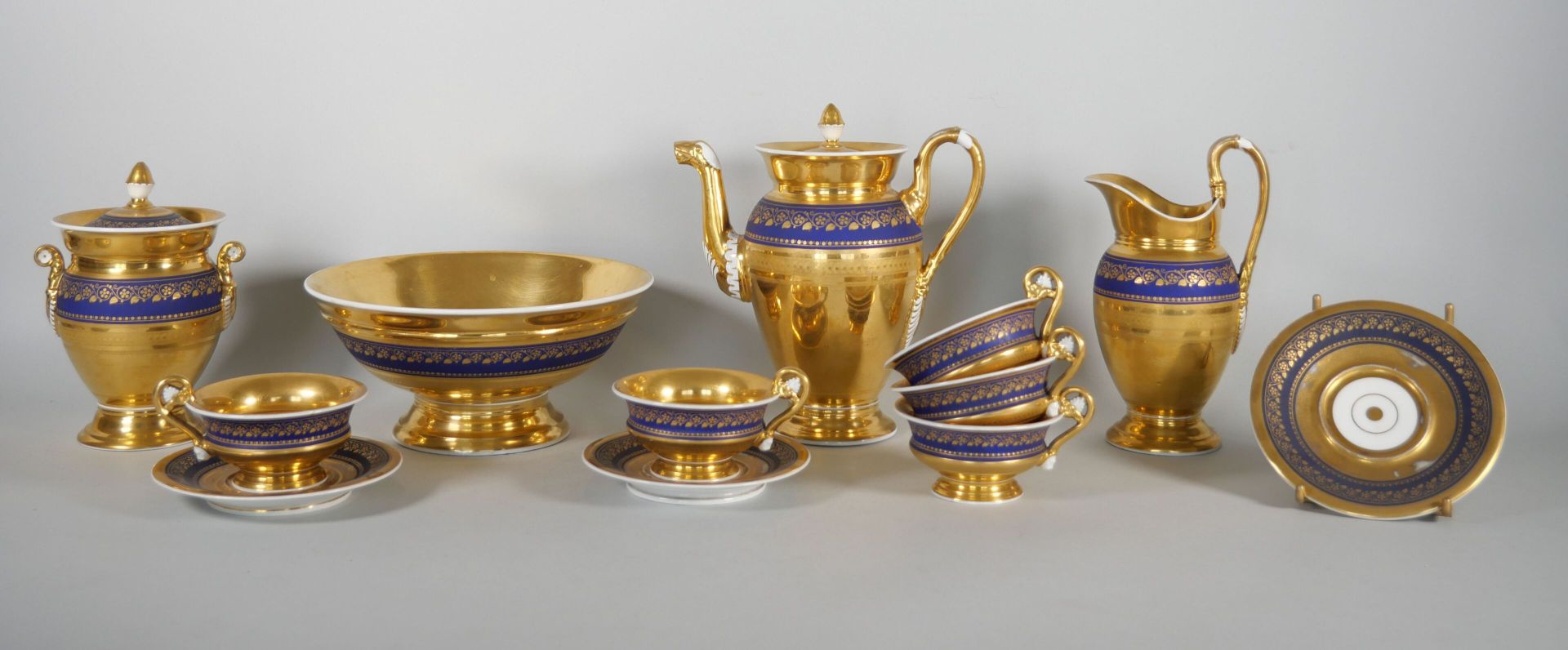 Null 巴黎：
瓷器茶具，在午夜蓝的背景上装饰着金色的楣，田野上有镀金和烧制的玛瑙。 
它包括： 
一个茶壶。高度：21厘米 
一个有盖糖碗。高度：16厘米 &hellip;