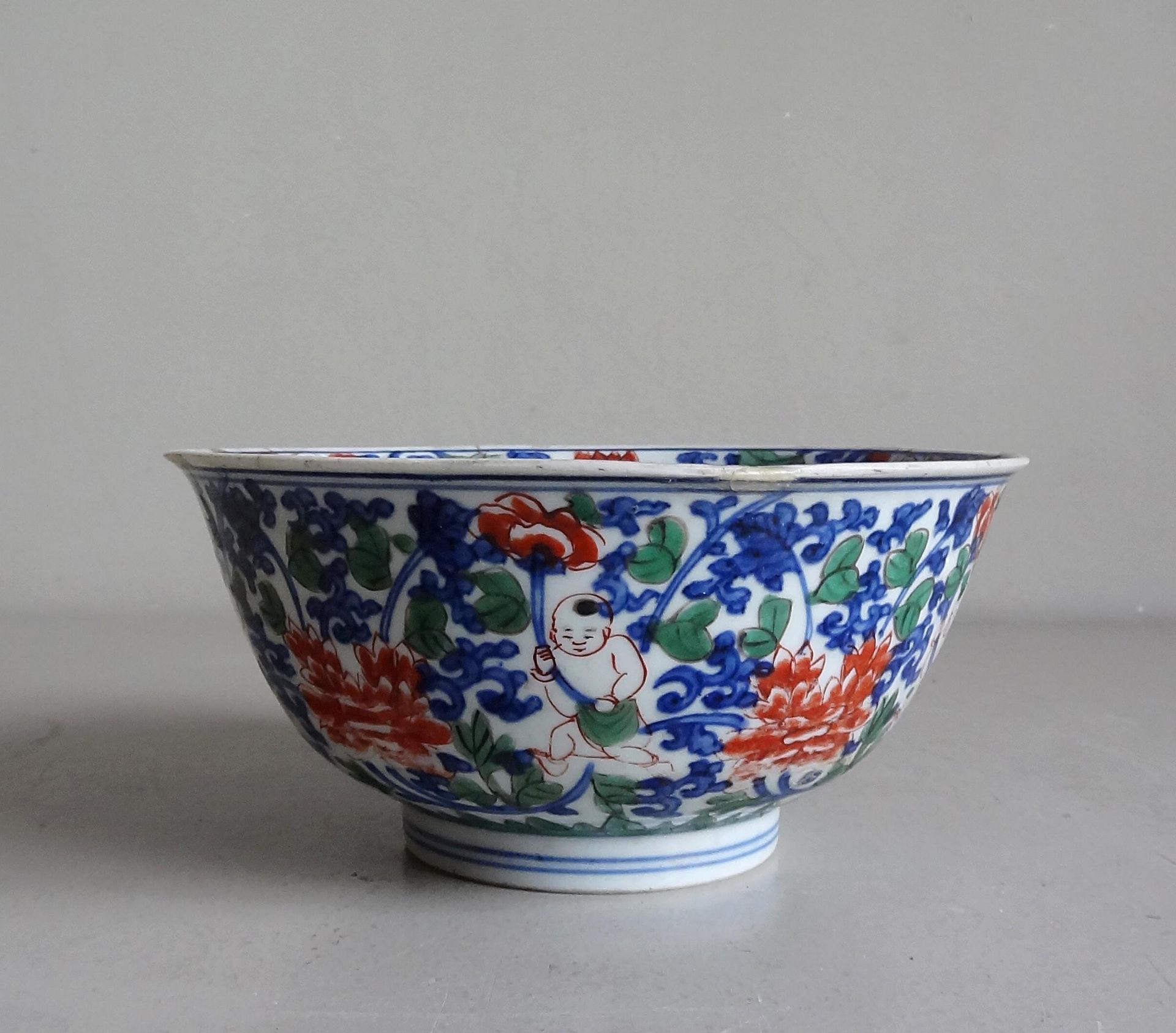 CHINE 中国

瓷碗在跟前，有儿童和花朵的多色装饰

19世纪

H.8厘米；D. 17.5厘米

破碎后重新粘在一起