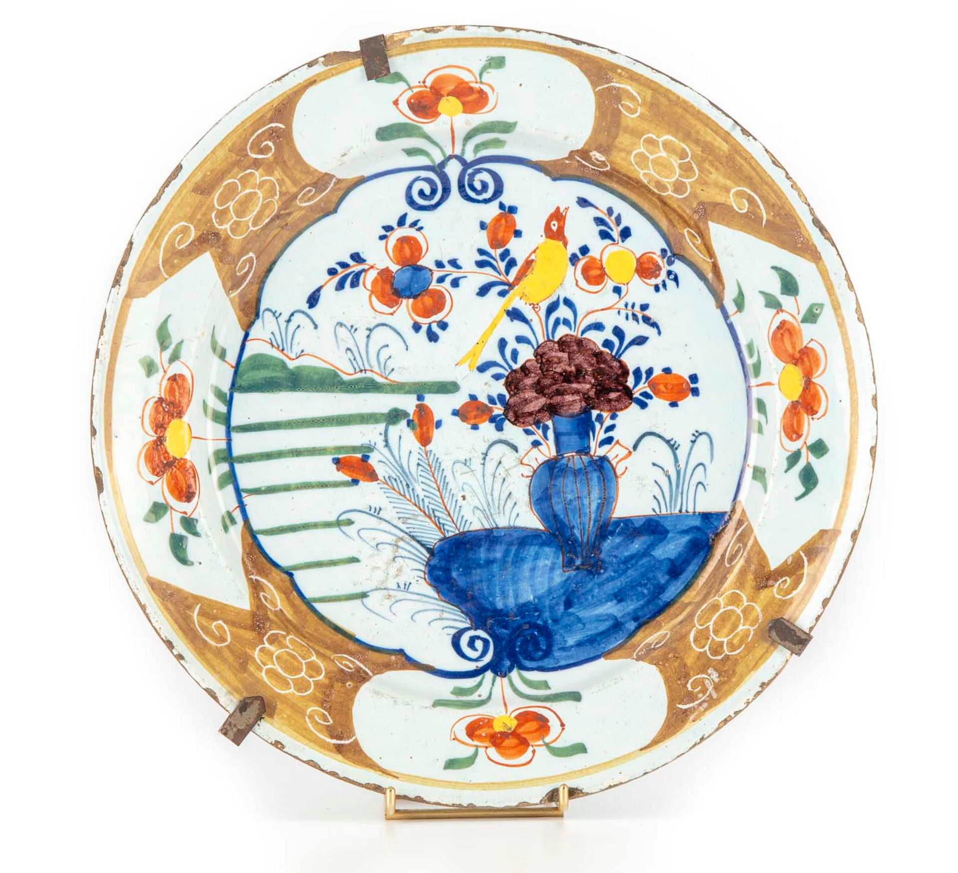 DELFT 德尔福

圆形陶器盘，多色装饰，上面有一只风景中的鸟的花瓶

镶有软垫的边框

18世纪

D.36厘米

边缘上的芯片