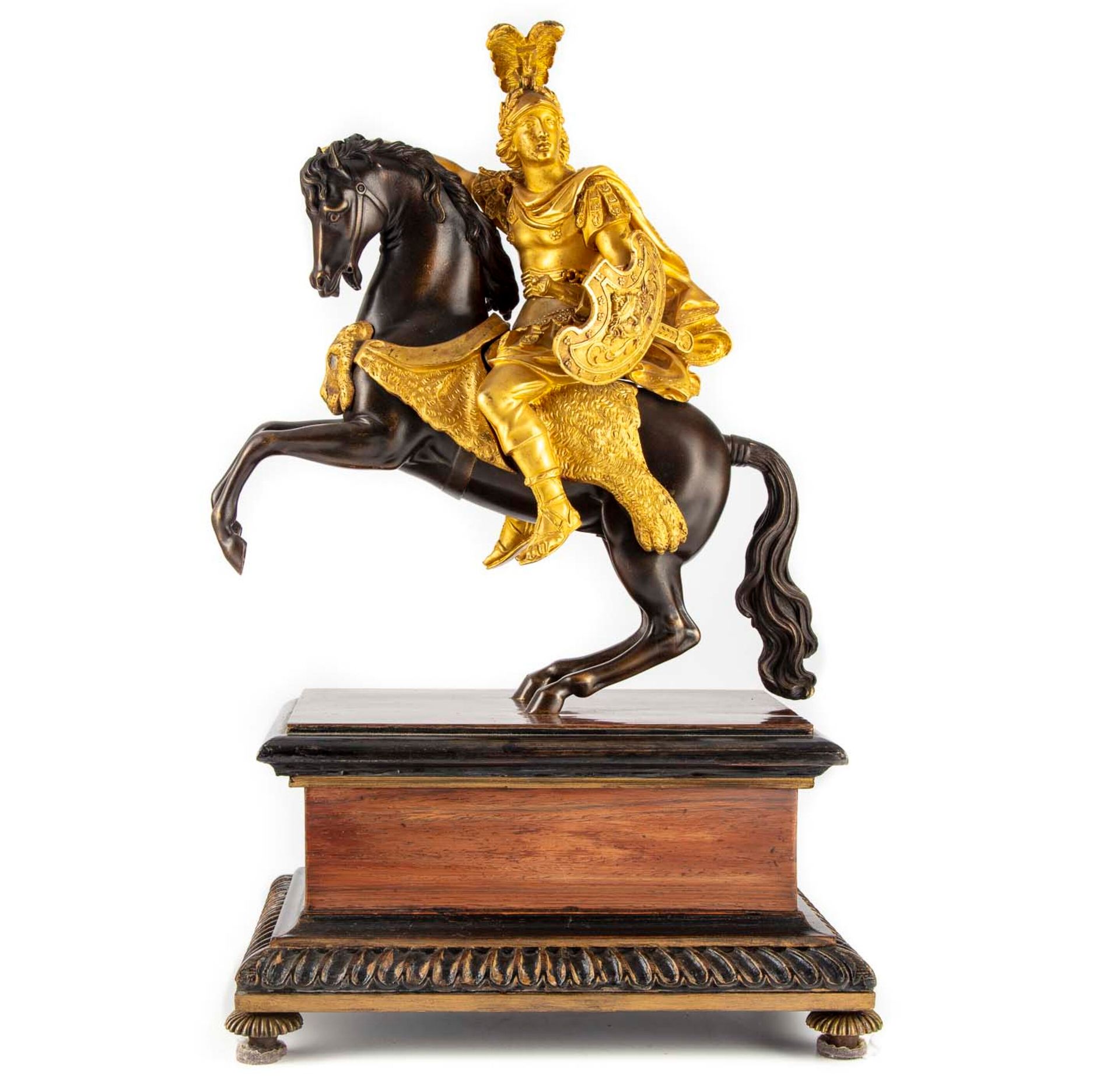 Null 带有两种铜锈的青铜雕像，表现了一个穿着古董风格的骑士，放在一个长方形的木皮底座上。

19世纪

H.47 cm; L. : 30 cm