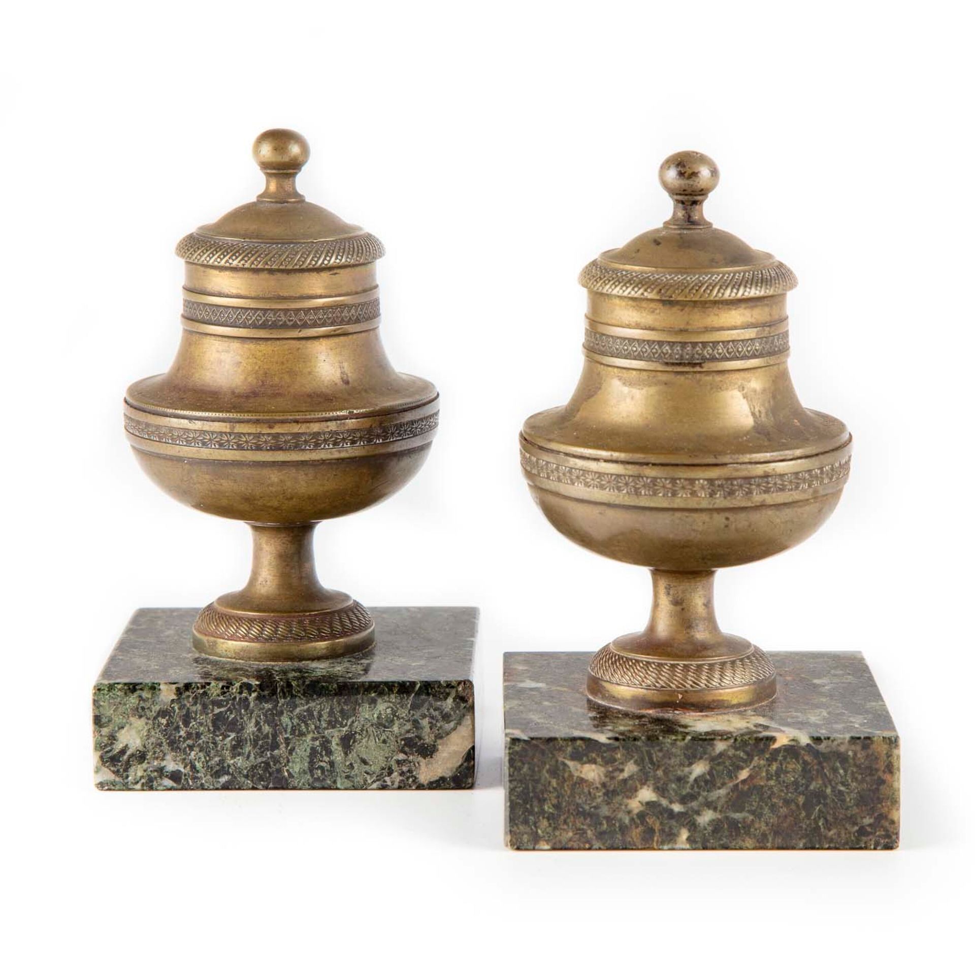 Null A pair of brass baluster paperweights resting on a marble base. 

H. 12 cm