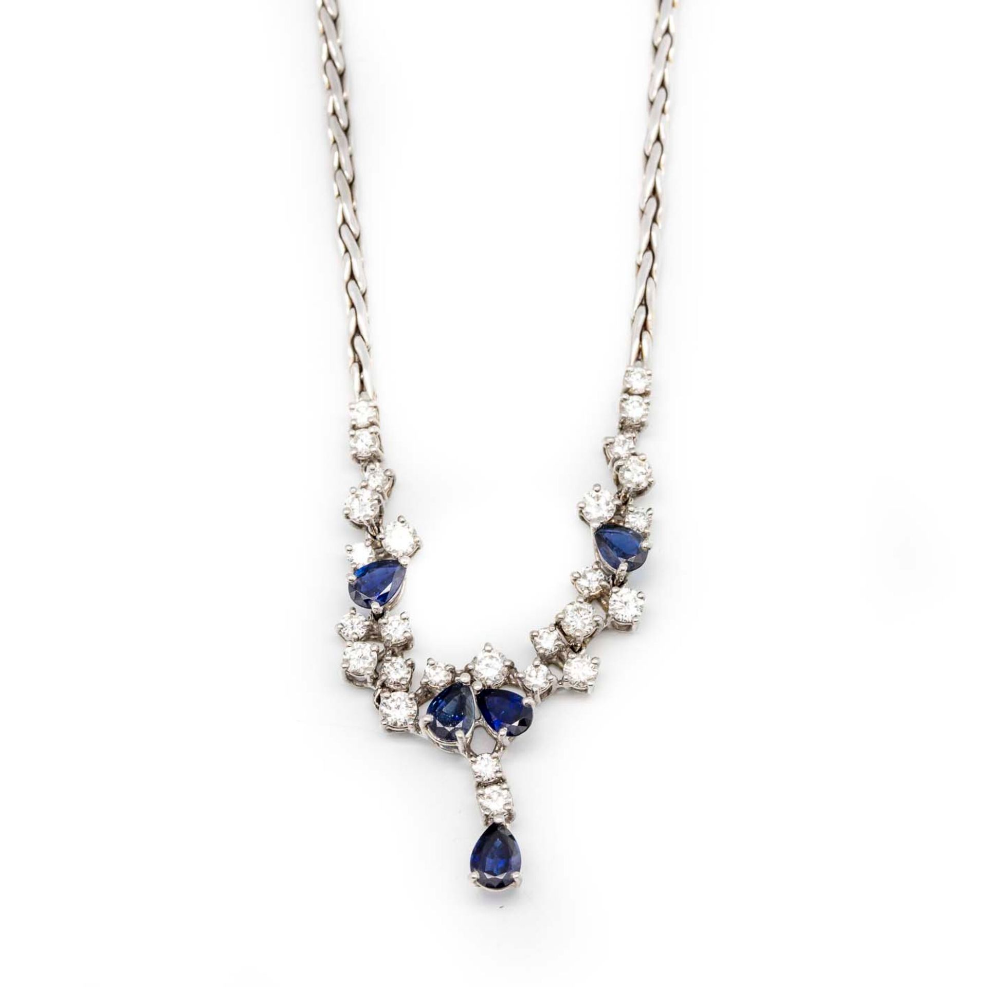 Null 白金项链，装饰有钻石和蓝宝石组成的五角形图案，最后是蓝宝石坠饰

毛重：20.7克。

约1960年

在其案例中