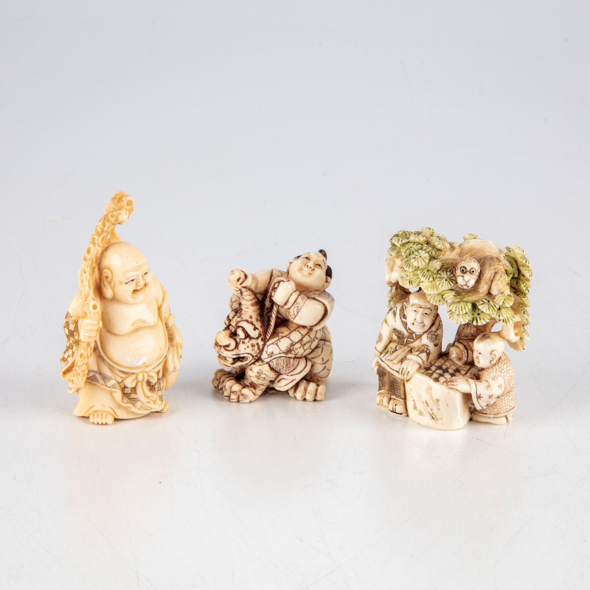 CHINE Trois netsuke en ivoire polychromé figurant : 

Un Bouddha tenant une bran&hellip;
