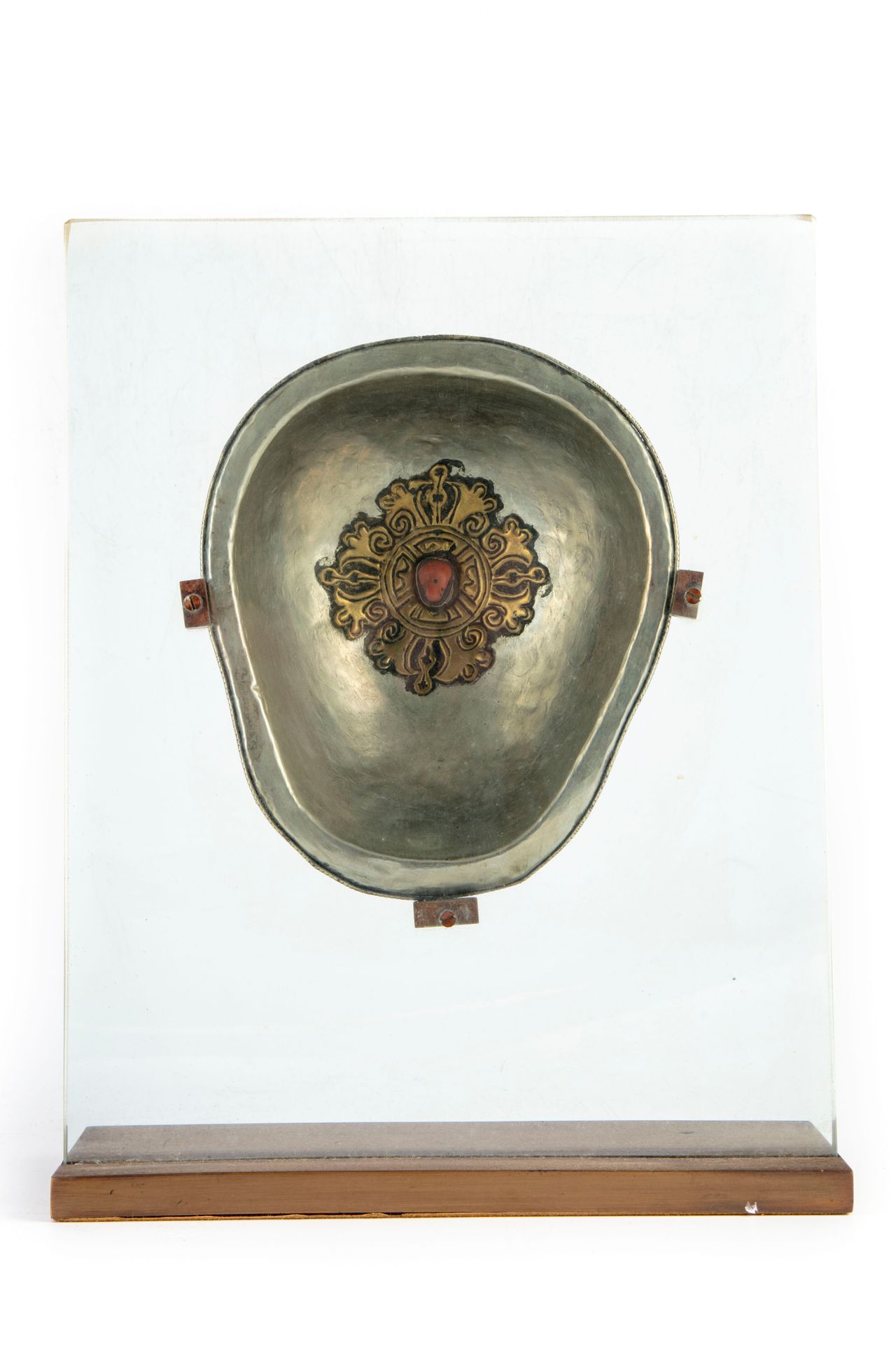 Kapala KAPALA 
一个由银衬里的头骨组成的酹酒杯，中间有一个凸圆形的叶子图案的装饰。 
古老的藏族作品 
玻璃和金属底座 
H.17和31厘米（底座&hellip;