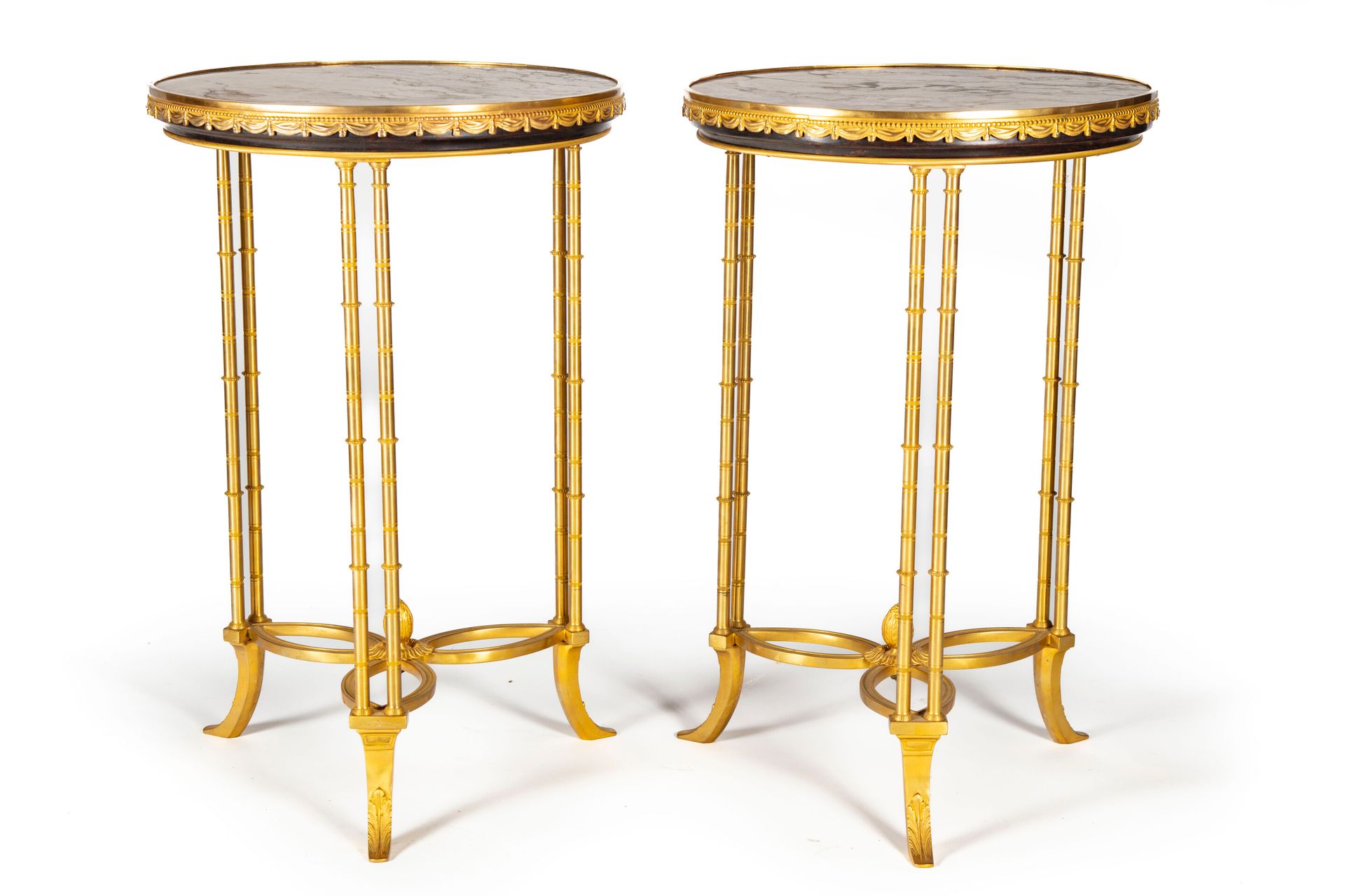 DANS LE GOUT DE WEISWEILER 一对路易十六风格的基座桌，圆形大理石桌面放在三个双柱状立柱上，立柱上有模仿竹子的滚花珠环，由支架连接，最后&hellip;