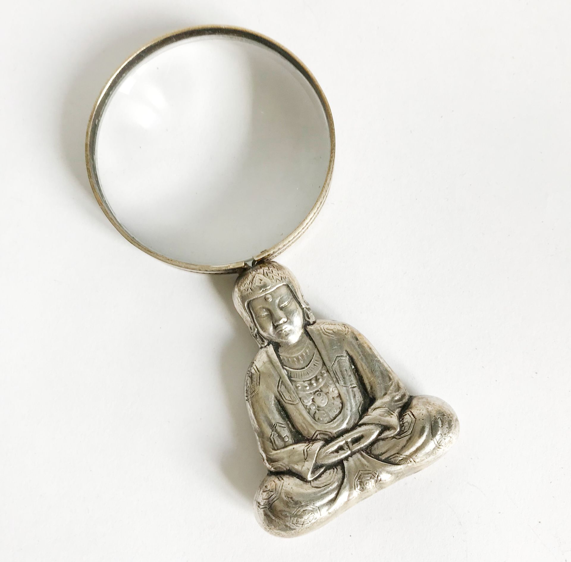Null 镀银金属框架的放大镜，手柄上凿有一尊坐着的佛像。

可能是亚洲的工作

H.12厘米左右。