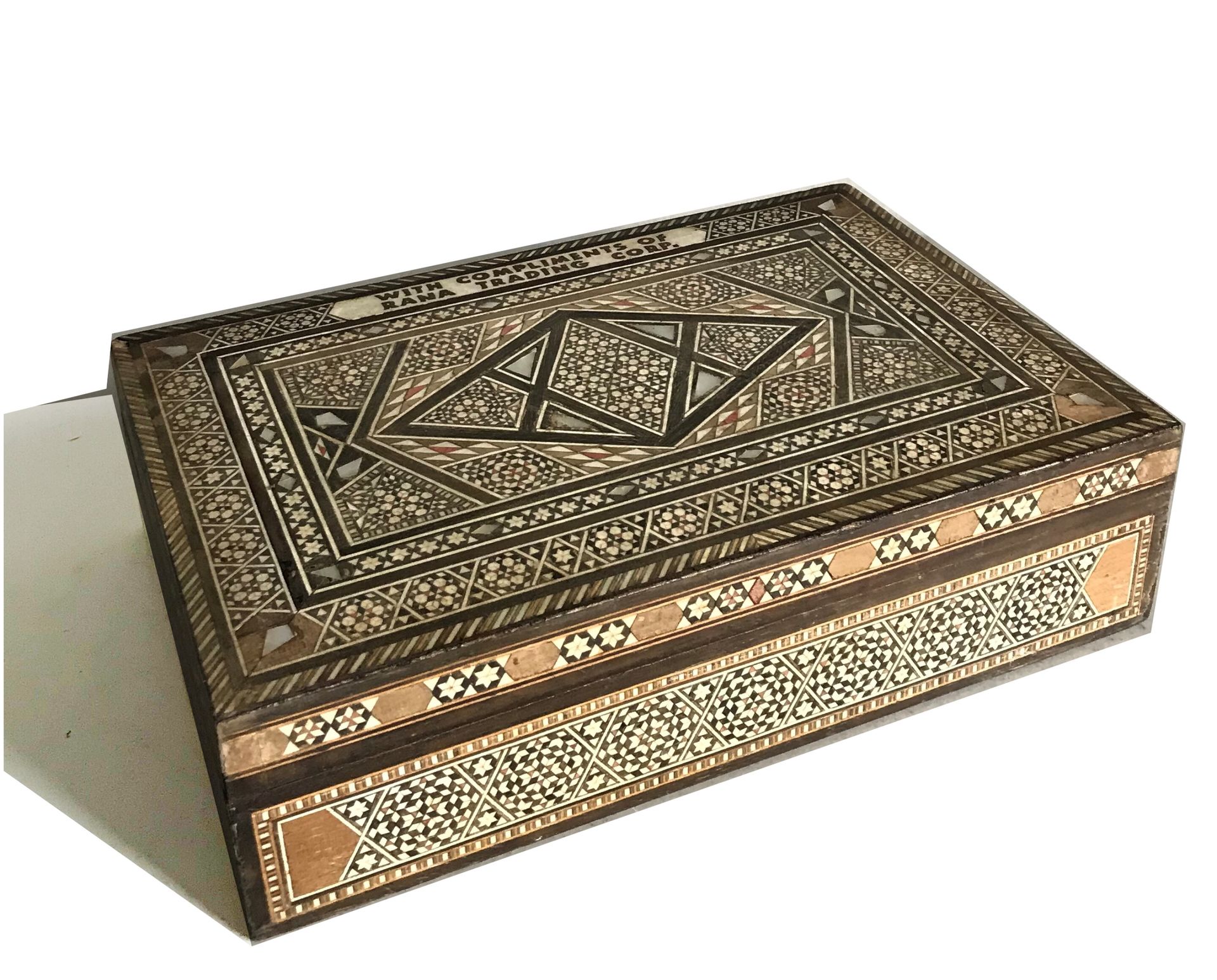 Null 长方形单板箱，装饰有各种木质、骨质和珍珠母的镶嵌物。盖子上有 "拉纳贸易公司致意 "的字样。

叙利亚风格的工作

H.8 - 宽29 - 深19厘米