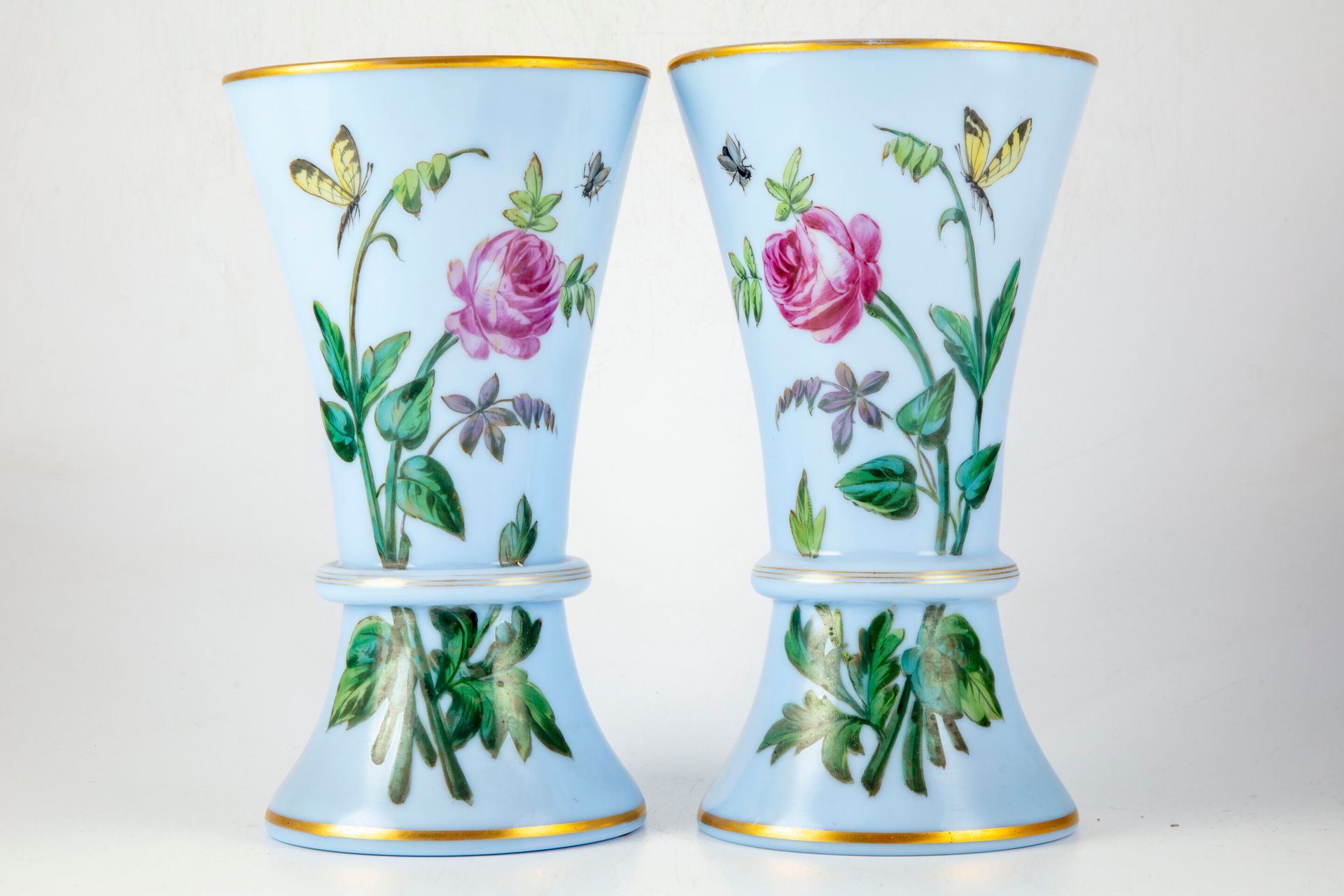 Null Coppia di vasi opalini blu decorati con fiori, farfalle e reti dorate

H. 3&hellip;