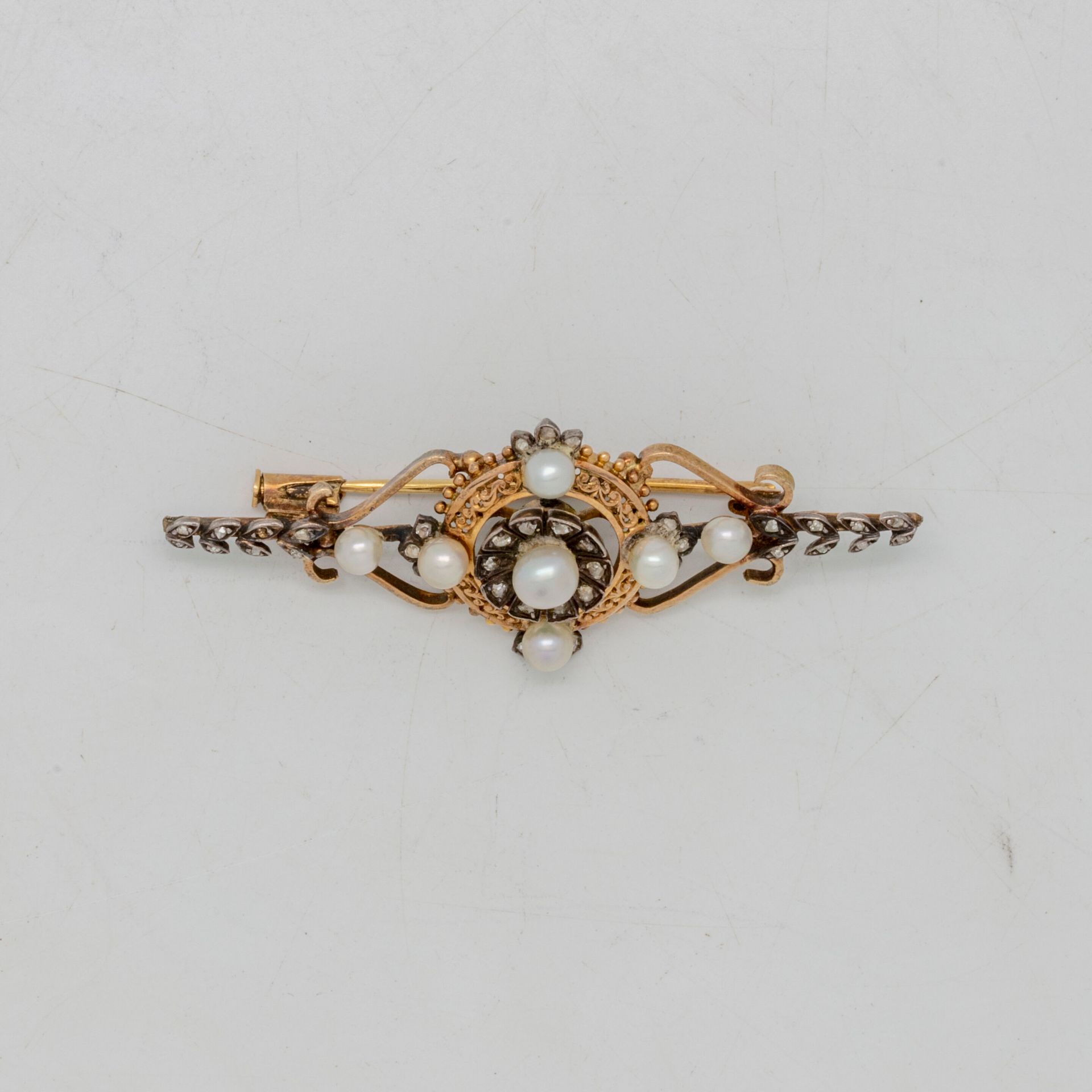 Null 镂空黄金胸针，中央图案上点缀着可能是精美的珍珠和小型玫瑰切割钻石

拿破仑三世时期

毛重：6.5克。