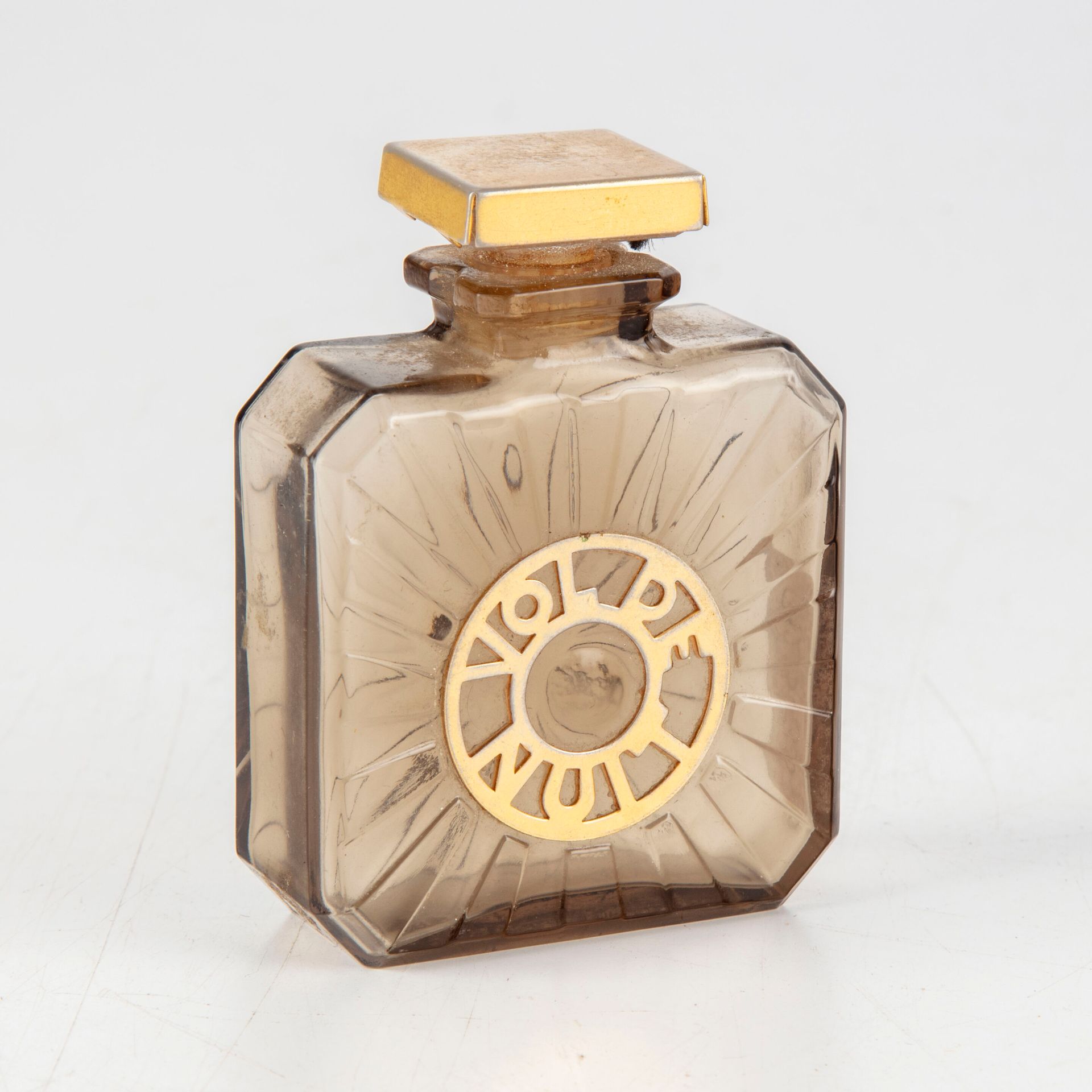 Null GUERLAIN之家 - 巴黎

香水 "Vol de nuit"，烟熏玻璃瓶，长方形截面，方形瓶身，两面有放射状装饰，一面有镂空黄铜标签装饰，其扁方&hellip;